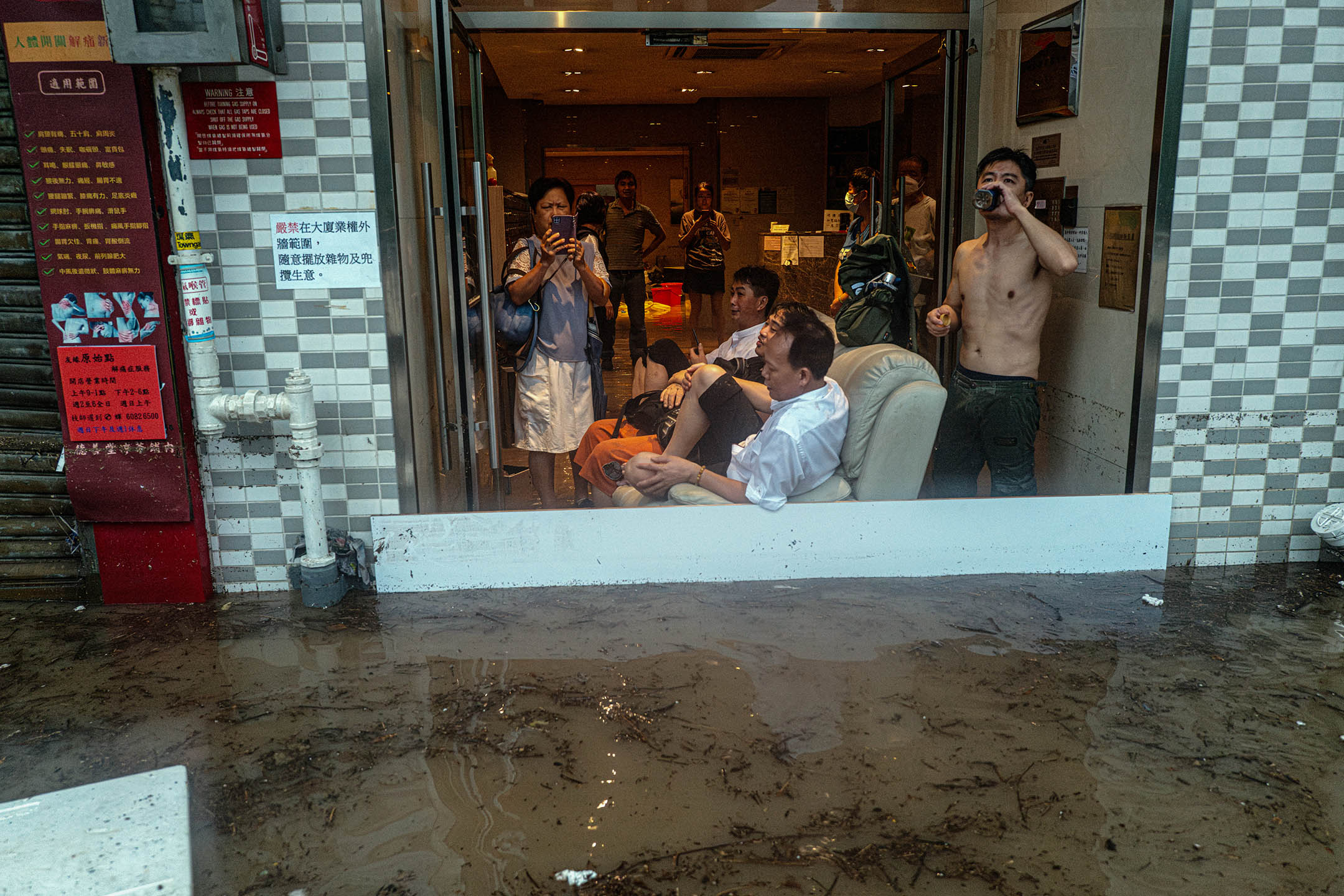 2023年9月8日,香港,暴雨期间,居民留在一座大楼观看窗外淹没了的街道。摄:Lam Yik/Bloomberg via Getty Images