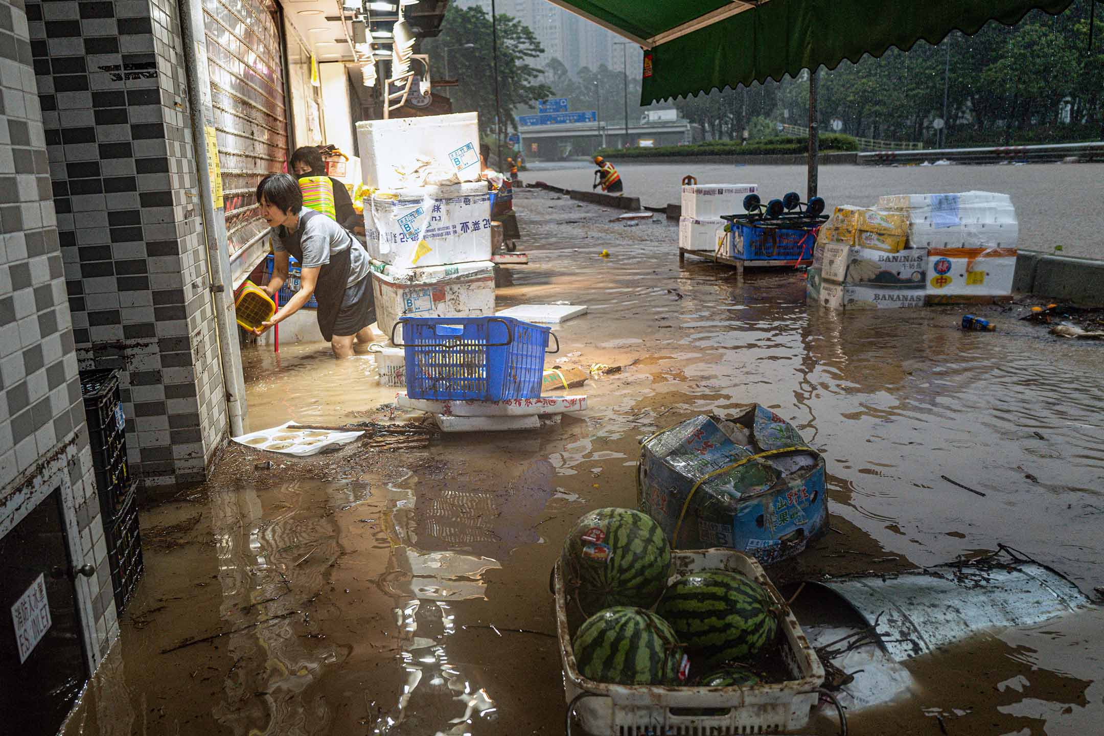 2023年9月8日,香港,暴雨期间,店主在处理被水淹没的商店。摄:Lam Yik/Bloomberg via Getty Images