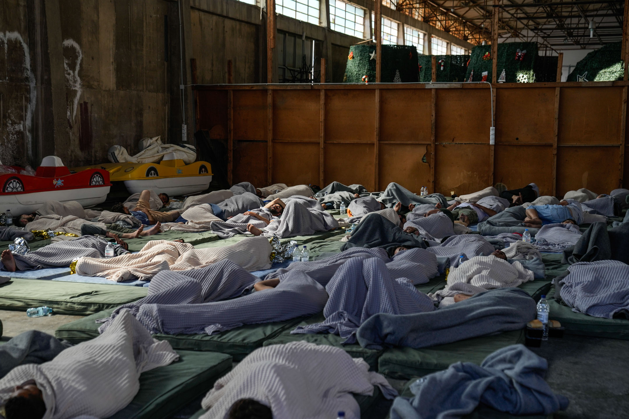 2023年6月14日，希臘，沉沒船隻的倖存者，在倉庫內休息。攝：Thanassis Stavrakis/AP/達志影像