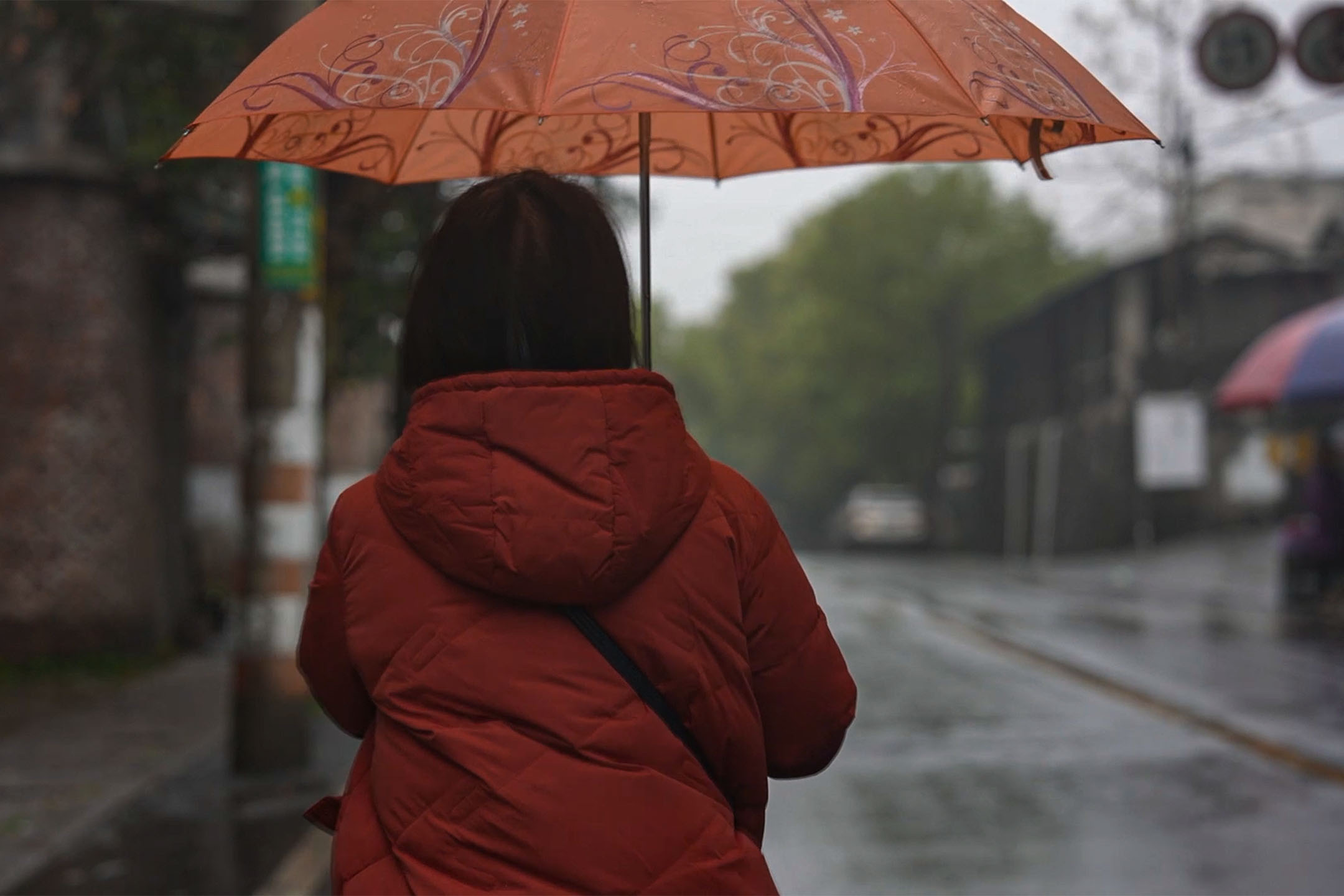 許小紅探望完劉滸後,走在回家的路上,天正在下雨。