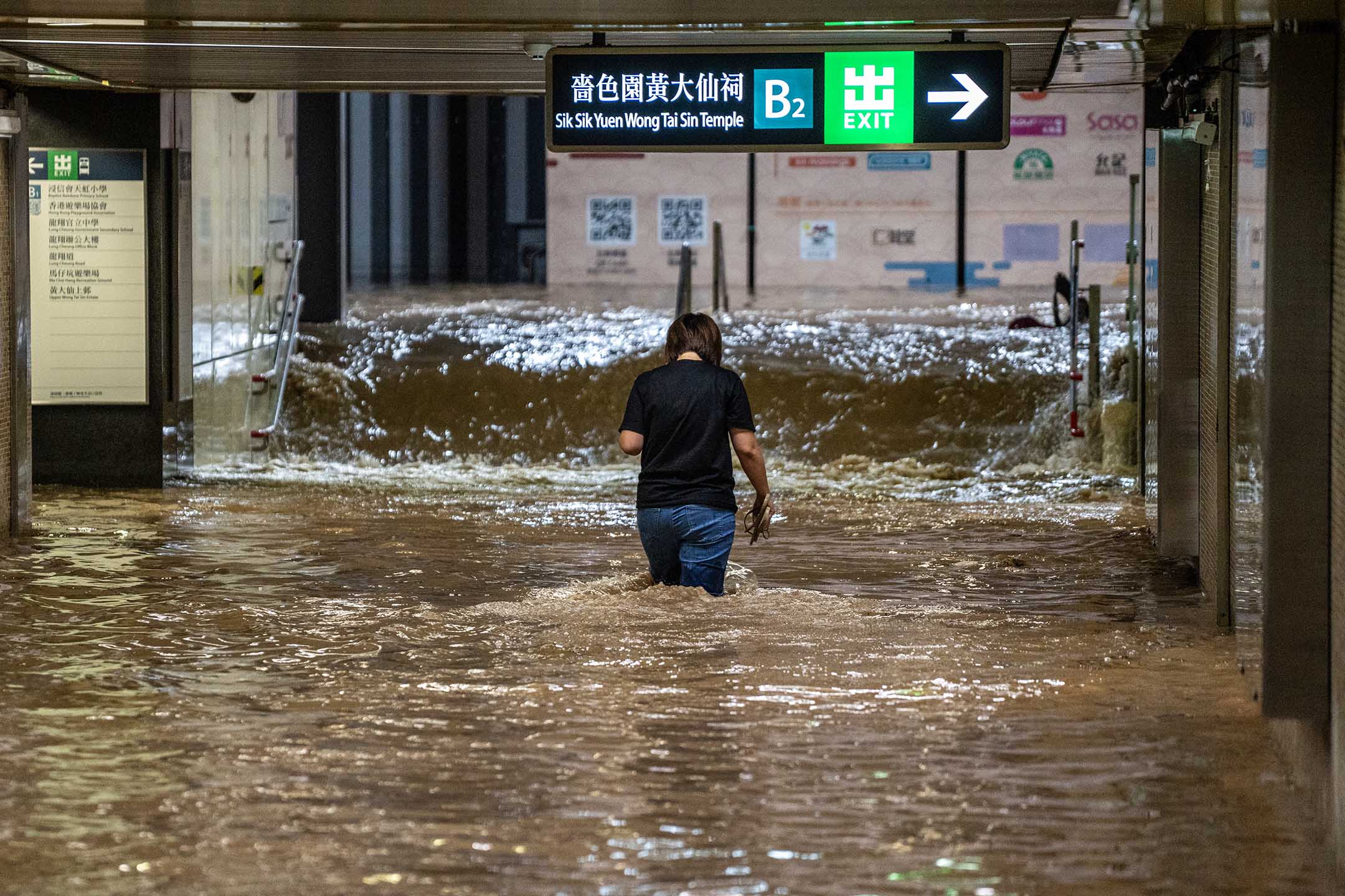 2023年9月8日,香港,暴雨期间,一名妇女在被水淹没的地铁站行走。摄:Vernon Yuen/NurPhoto via Getty Images