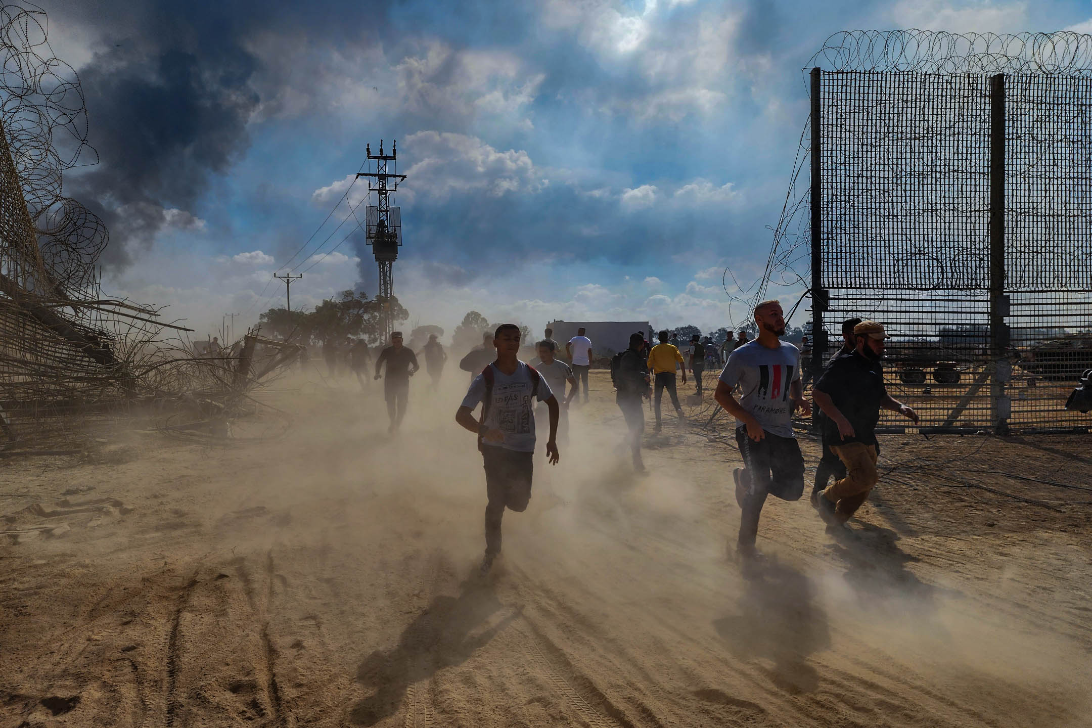 2023年10月7日,巴勒斯坦人拆除以色列与加萨边境的围栏。摄:Hani Alshaer/Anadolu Agency via Getty Images