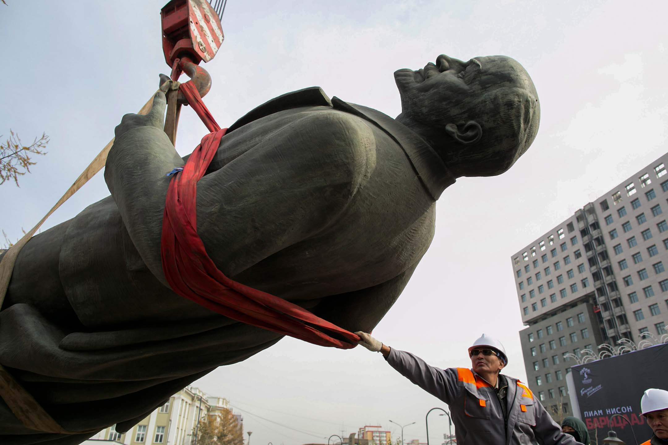 2012年10月14日,蒙古乌兰巴托,一名工人抓住列宁雕像,用起重机将其拆除并放在卡车上。