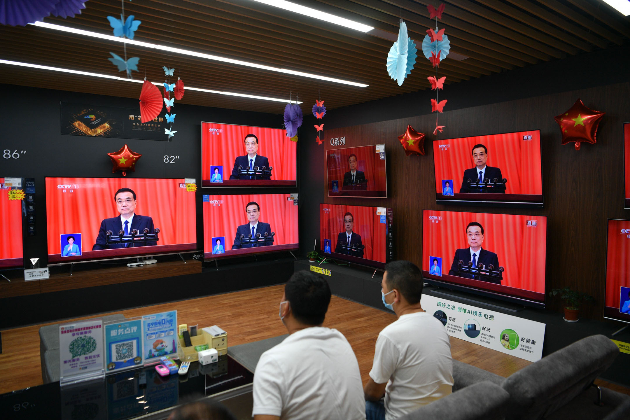 2020年5月22日，昆明，市民戴著口罩在電器店內觀看中國總理李克強講話直播。攝：Liu Ranyang/China News Service via Getty Images