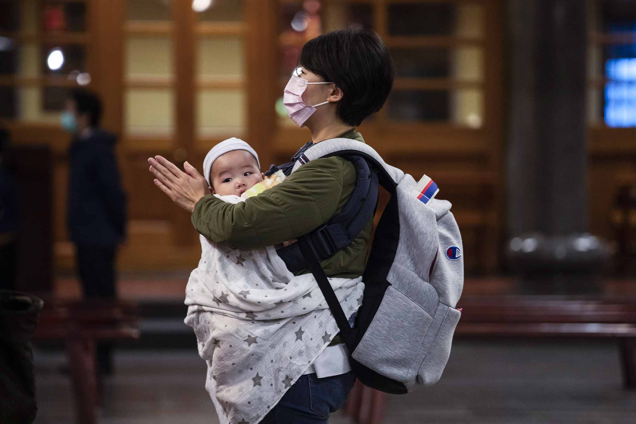 2020年3月17日,台北,一位母亲带著她的孩子祈福。摄:Paula Bronstein/Getty Images