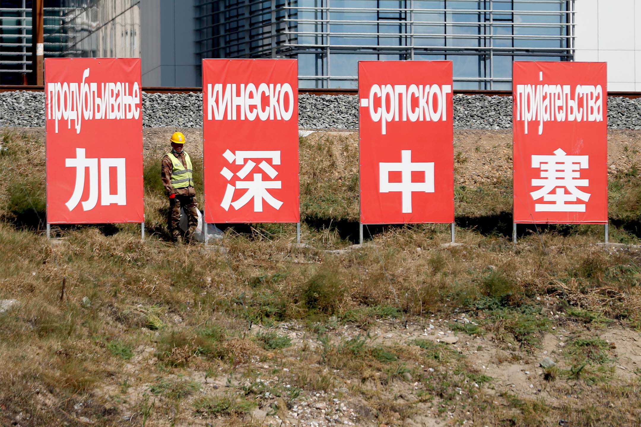2020年9月14日,一名工人站在铁路上的“加强中塞”的广告板旁。摄:Darko Vojinovic/AP/达志影像
