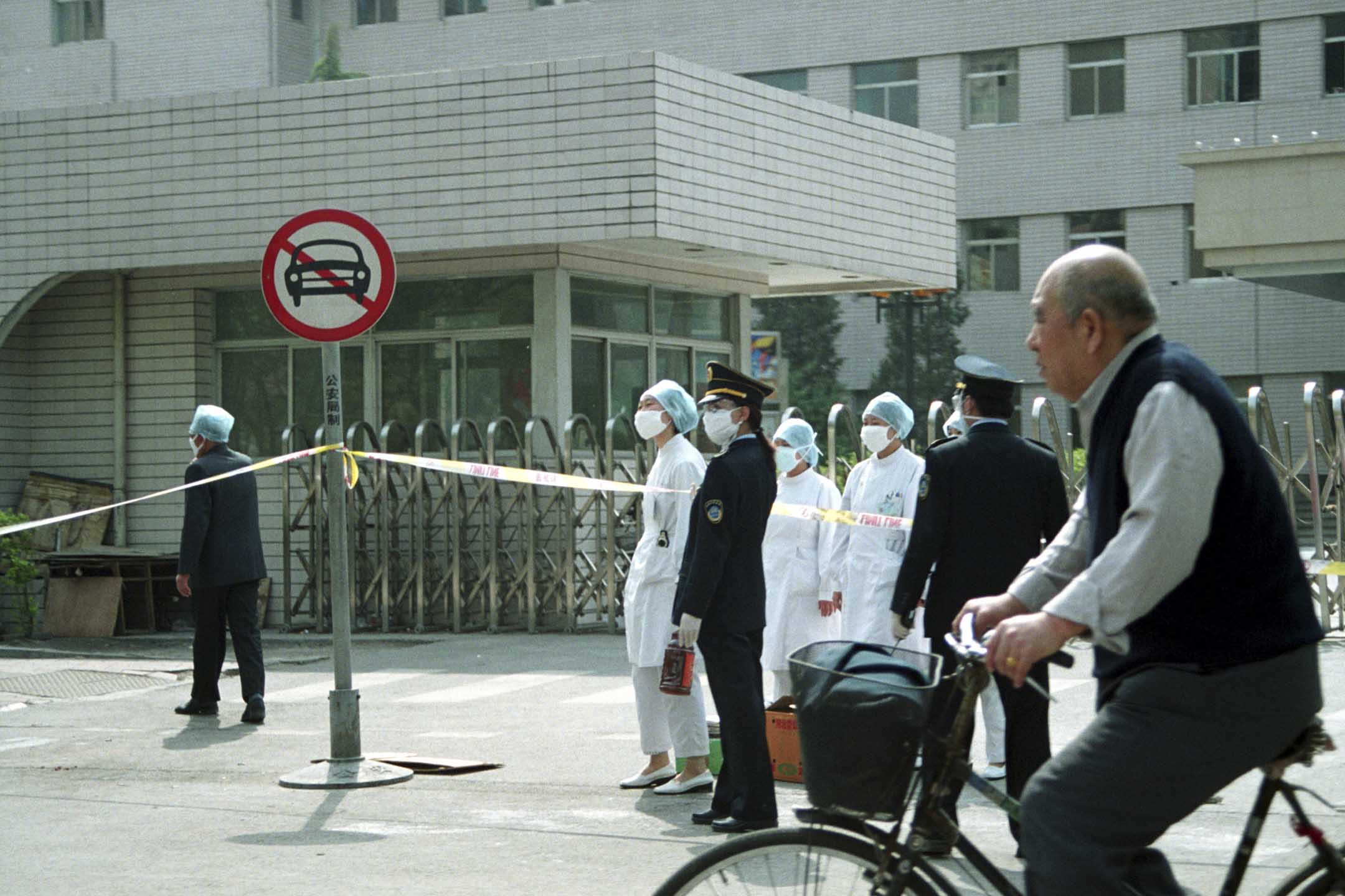 2003年4月25日,中國北京爆發SARS,警察站在被封鎖的人民醫院門口。圖: Getty Images