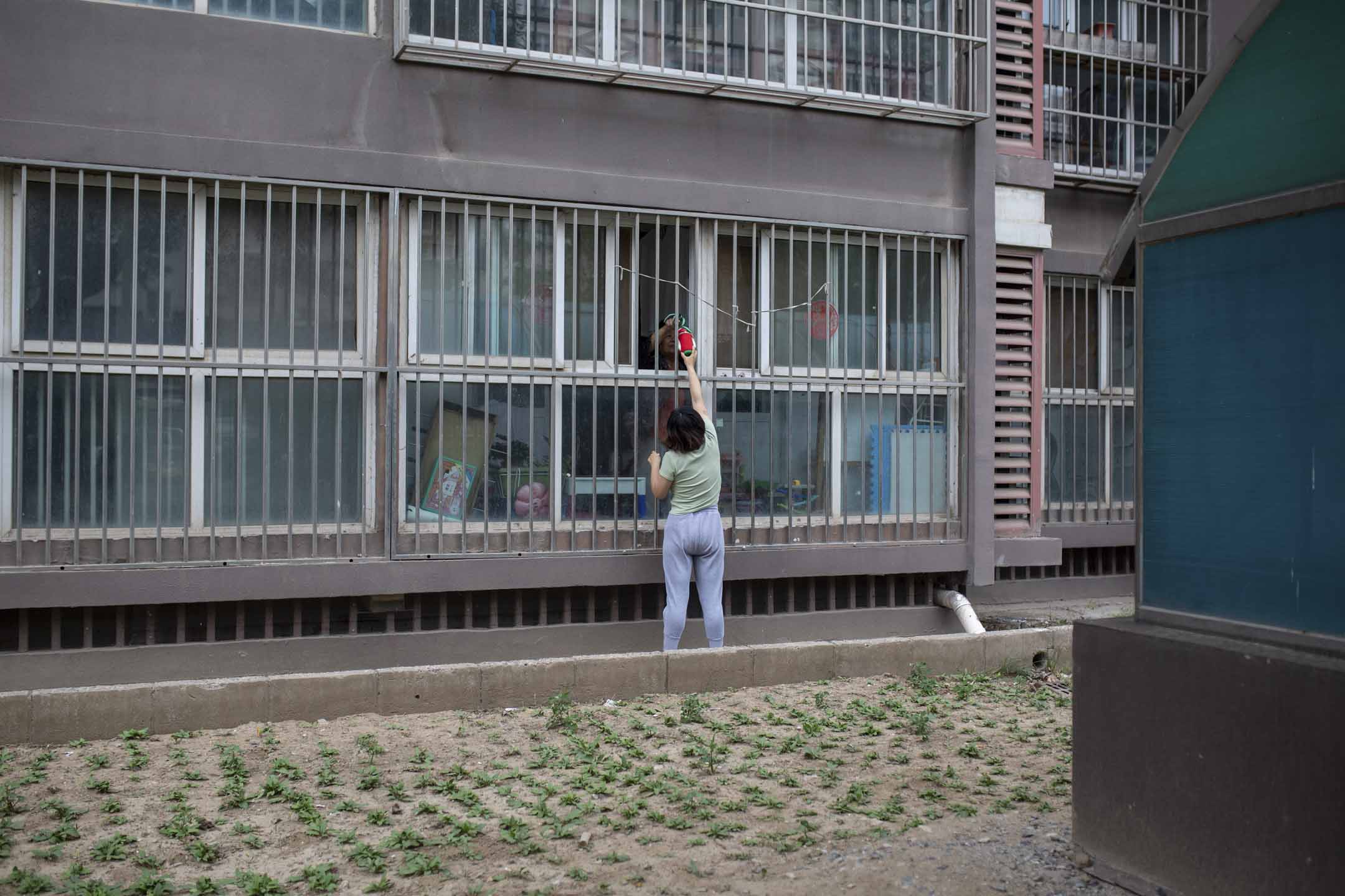 母女倆隔着窗戶交流。 攝影:夏天