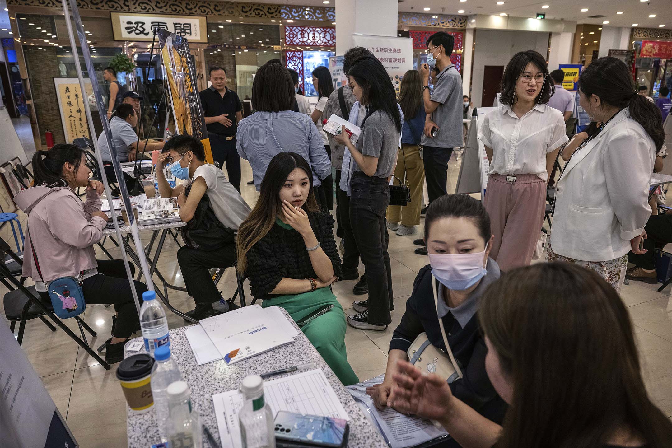 2023年6月9日,北京舉行的招聘會上,求職者和招募人員交談。攝:Kevin Frayer/Getty Images