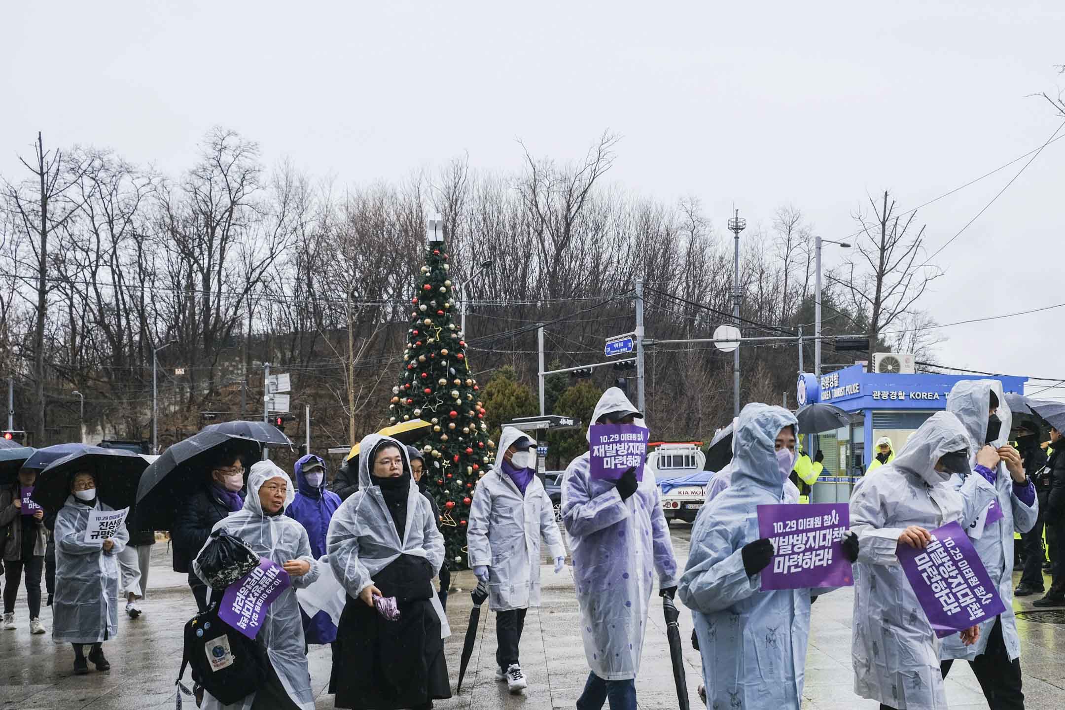 2023年12月14日,天下起大雨,遺屬在綠莎坪站廣場出發,徒步跨過漢江橋,遊行到對岸的國會大樓。攝:余美霞/端傳媒