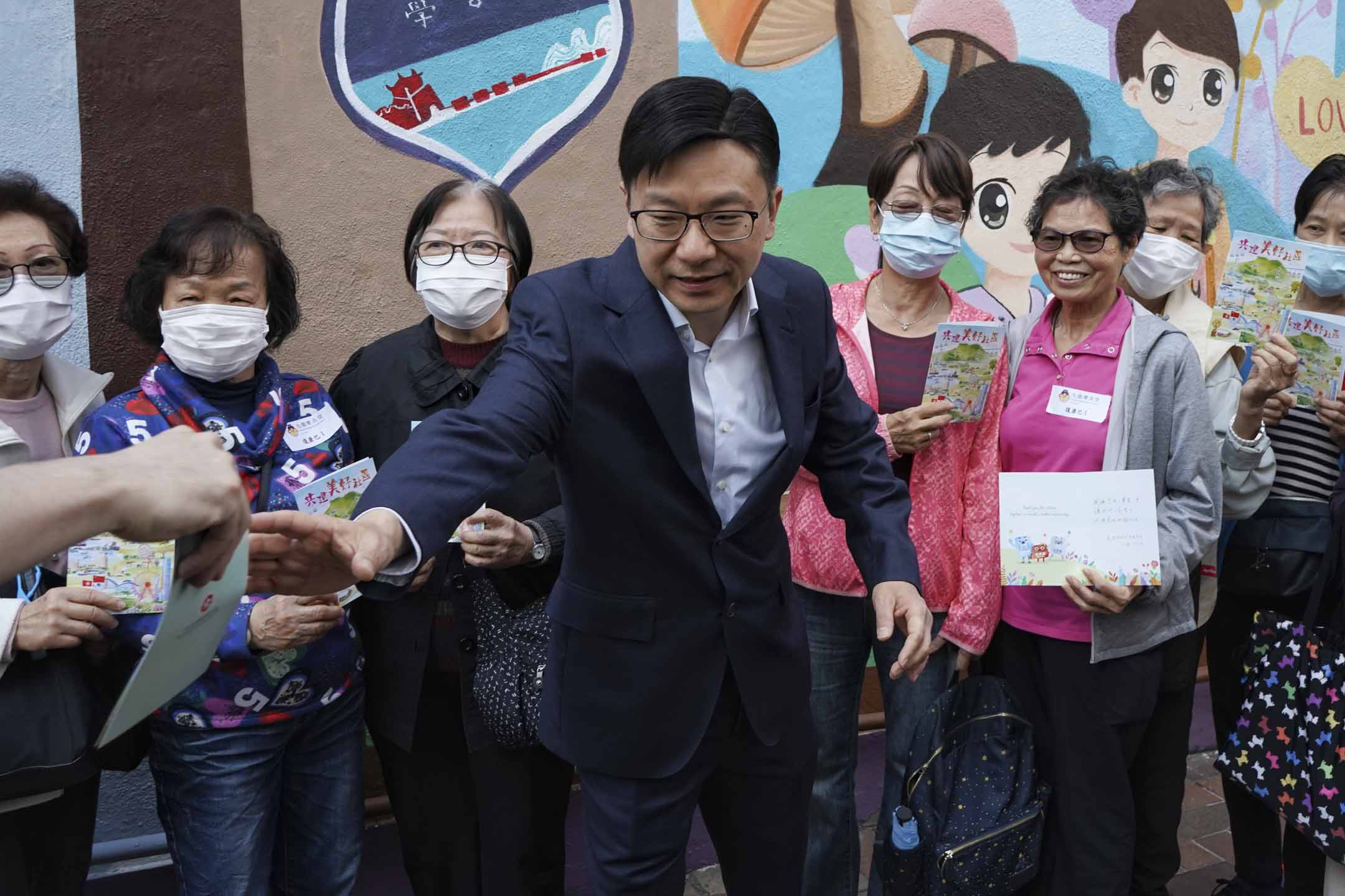 2023年12月10日,劳工及福利局局长孙玉菡早上在荃湾当义工协助长者,扶他们上巴士并步行往票站投票。 摄:David Chan/端传媒