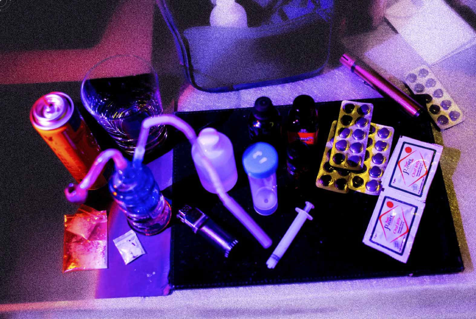 左下角是冰,使用冰壺需要點火,旁邊有汽油罐及火機。正中間是 G 水,需要時先用針筒量度份量放入杯中,然後混合少量稱為 mixer 的飲料(例如 Monster Energy 或可樂等)才能飲用。右邊是液體偉哥(Viagra,威而鋼)、Poppers 以及啫喱偉哥。攝:林振東/端傳媒