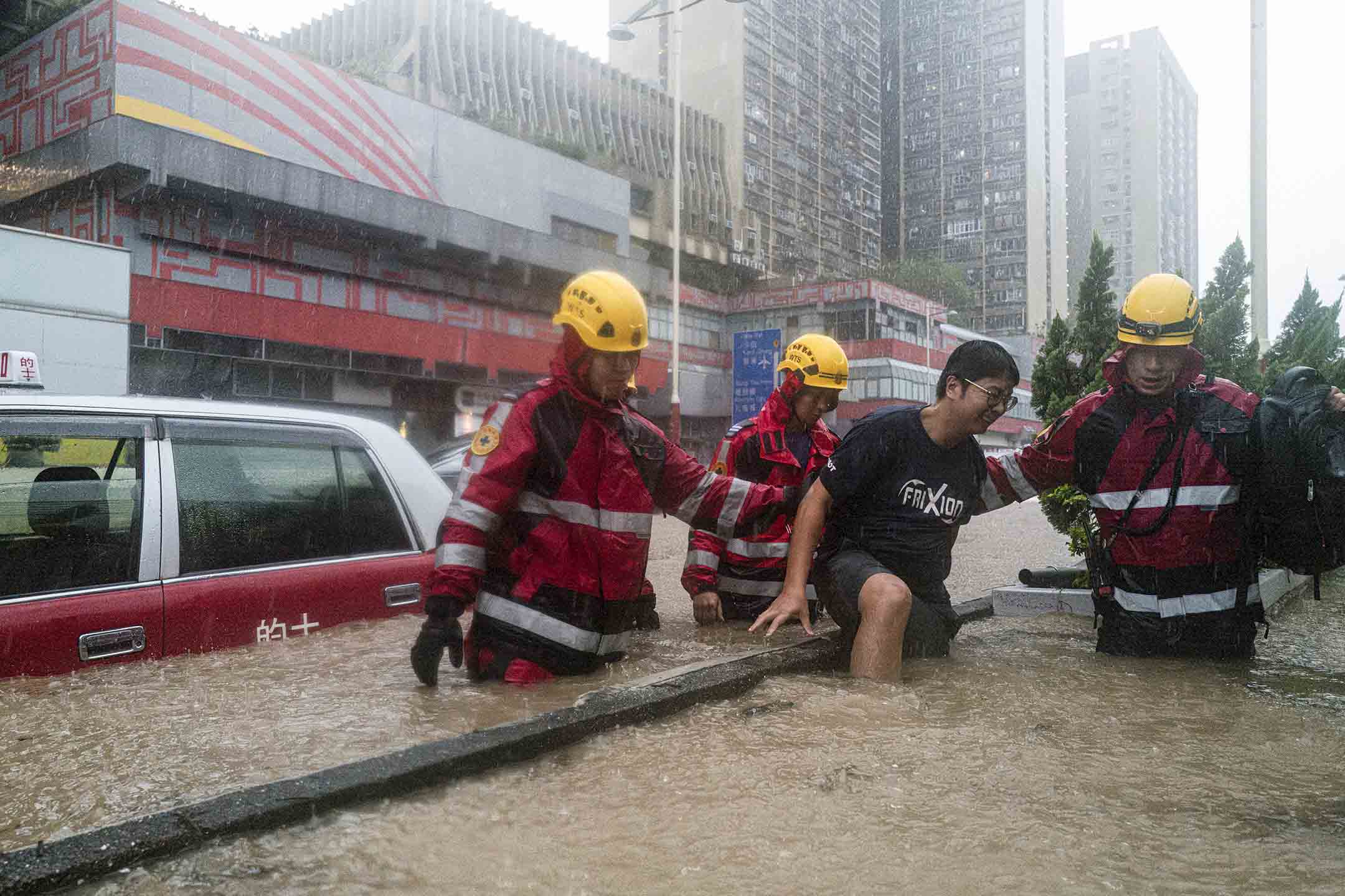 2023年9月8日,香港,消防員在暴雨中救助被洪水圍困的市民。攝:Lam Yik/Bloomberg via Getty Images