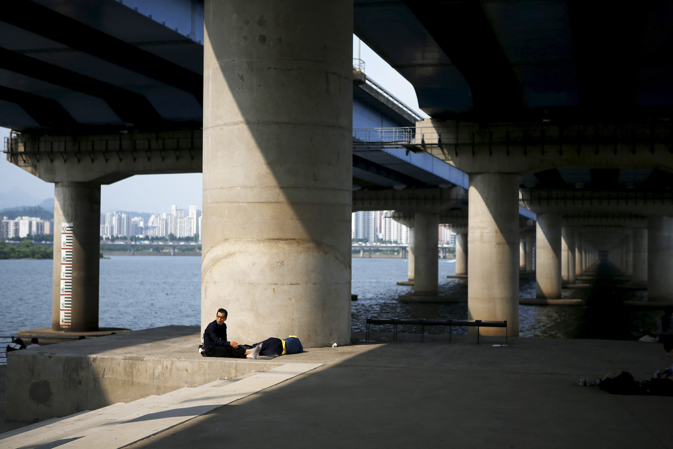 2015年6月22日,韓國首爾漢江公園,一名男人在橋下休息。攝:Kim Hong-Ji/Reuters/達志影像