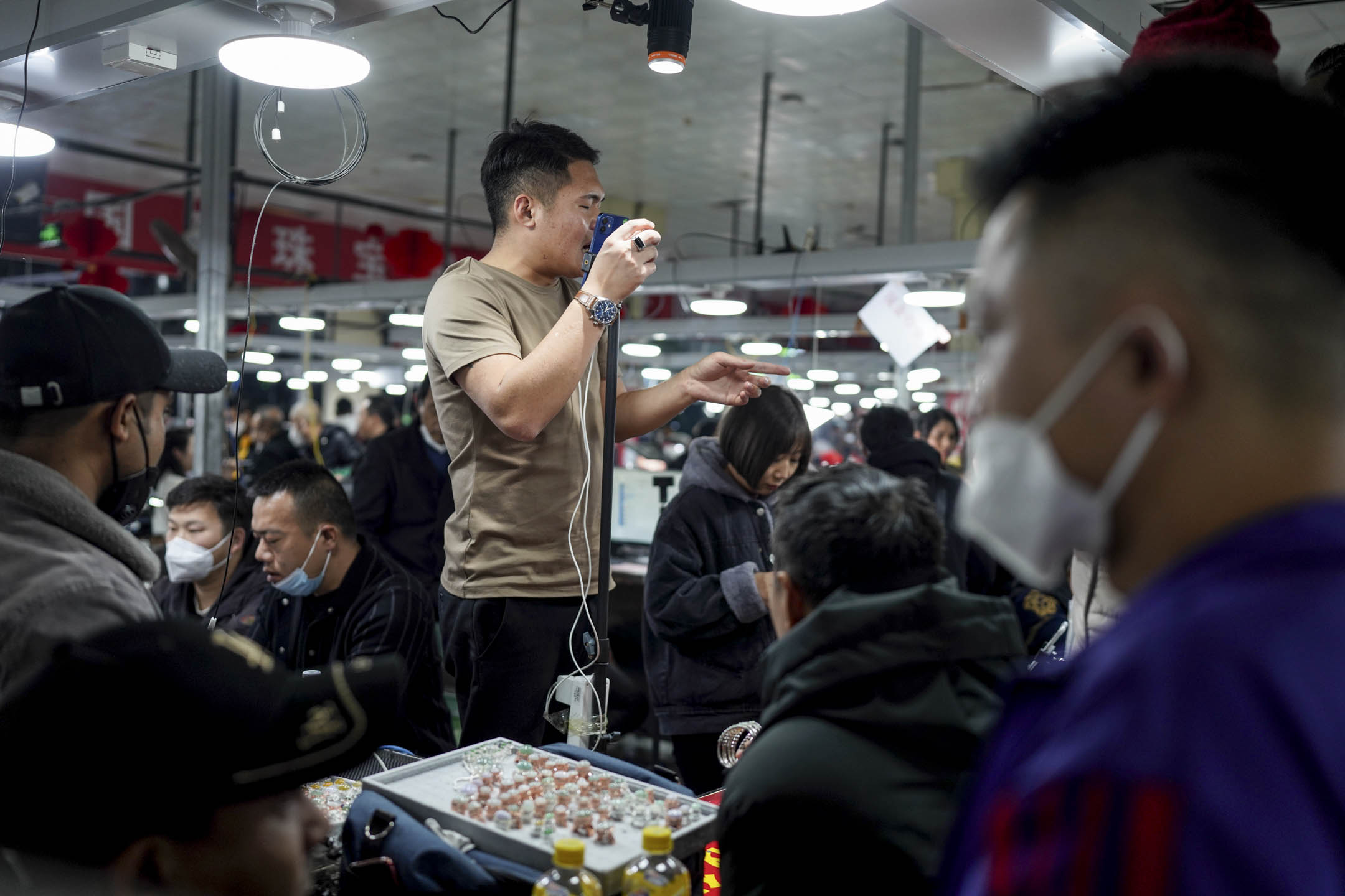 2023年1月13日,中国云南瑞丽市玉石交易市场,一名商贩透过手机直播贩售玉石。摄:Kang Ping/China News Service/VCG via Getty Images