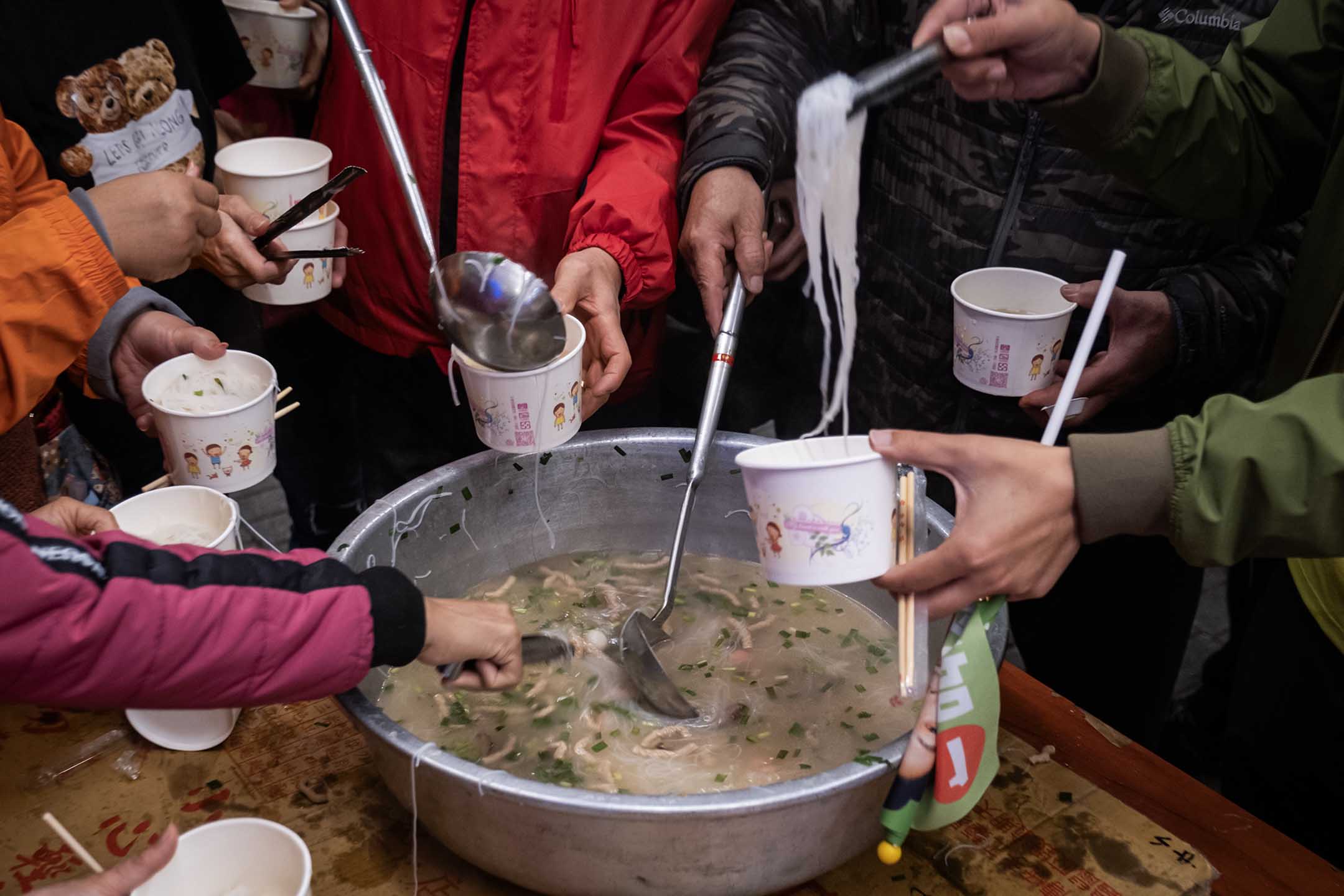 2023年12月26日,新北市,民进党立委候选人吴峥参香拜票,宫庙内的民众一起吃米粉等食物。摄:陈焯煇/端传媒