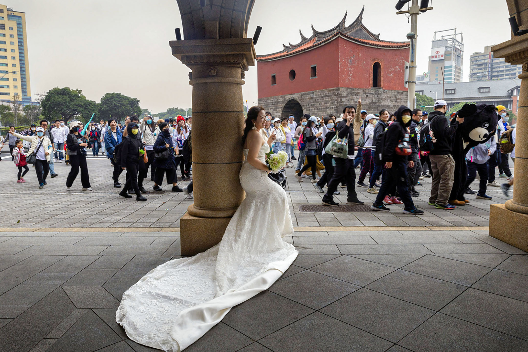 2023年12月31日,台北,民众党的造势游行期间,一名女生在拍婚纱照。摄:陈焯煇/端传媒