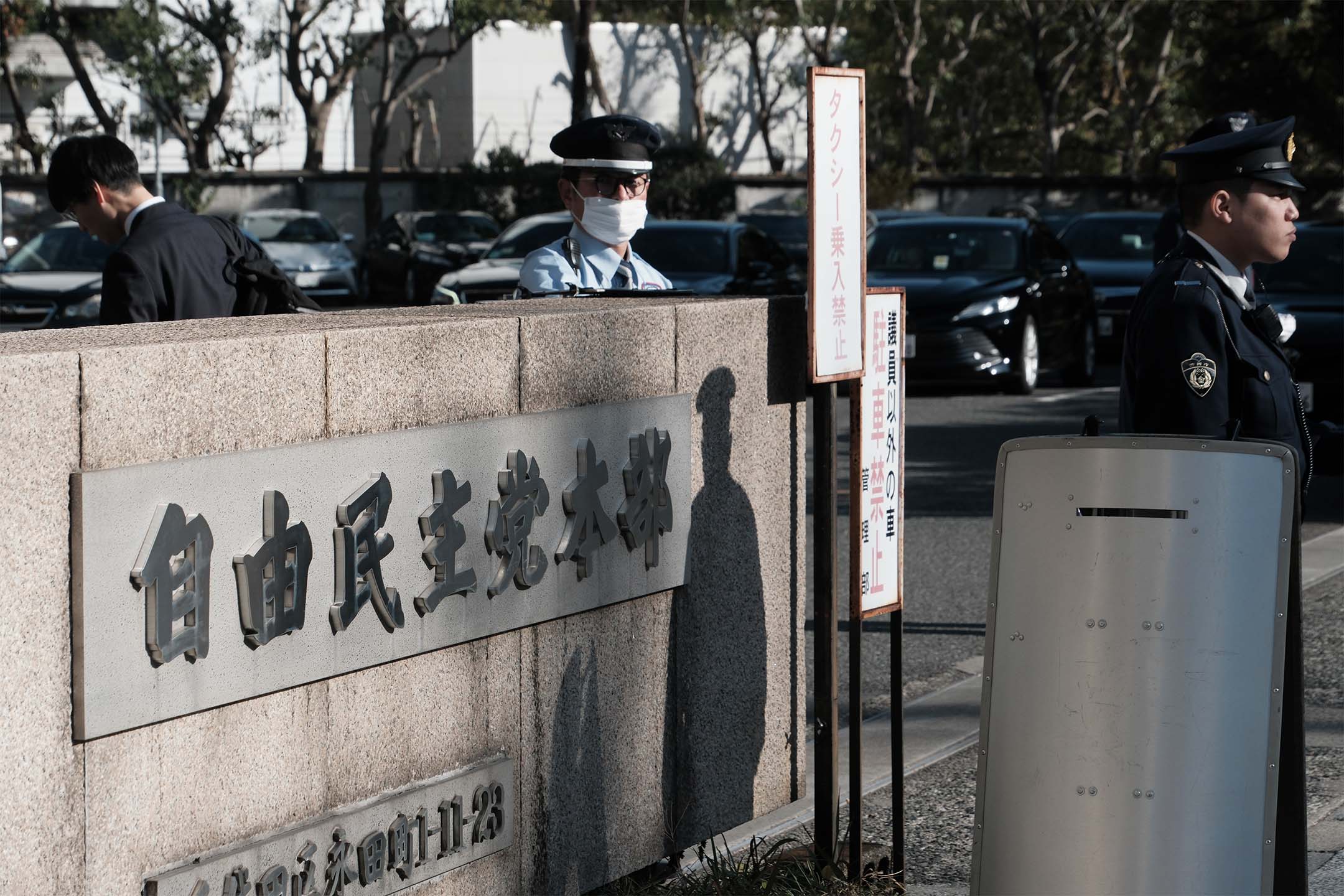 2023年12月14日,日本東京,警察站在自民黨總部外。攝:Soichiro Koriyama/Bloomberg via Getty Images