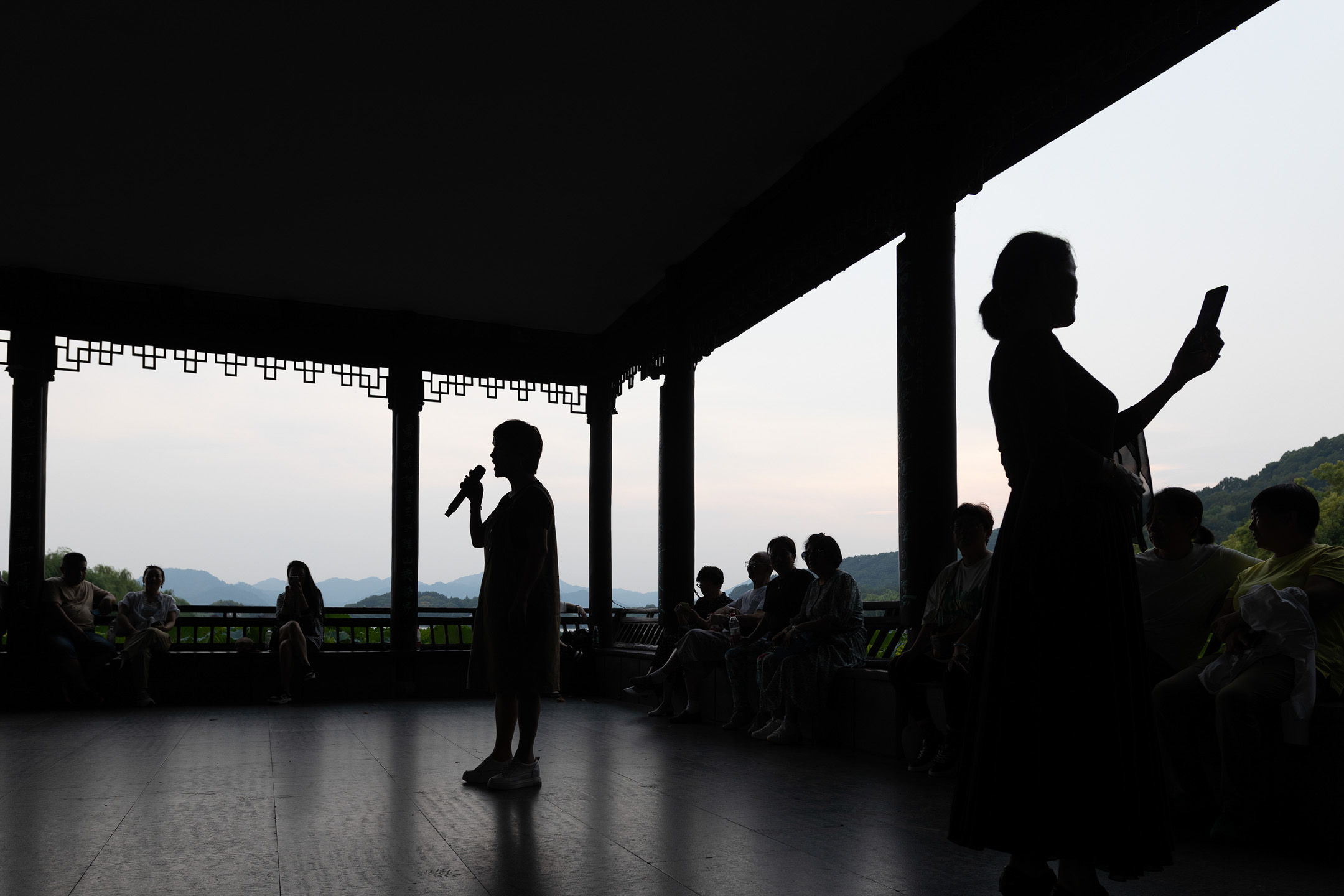 2023年9月12日,中国杭州,女士们在西湖旁边唱歌。摄:Hugo Hu/Getty Images