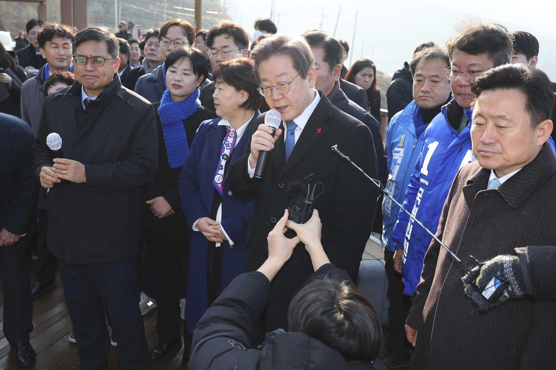 2024年1年2日,韩国反对党领袖李在明参观釜山加德岛新机场,正在与记者进行问答时,突然遭到一名不明身份男子持刀朝左颈部攻击,倒在地上。摄:Sohn Hyung-joo/Yonhap via AP/达志影像