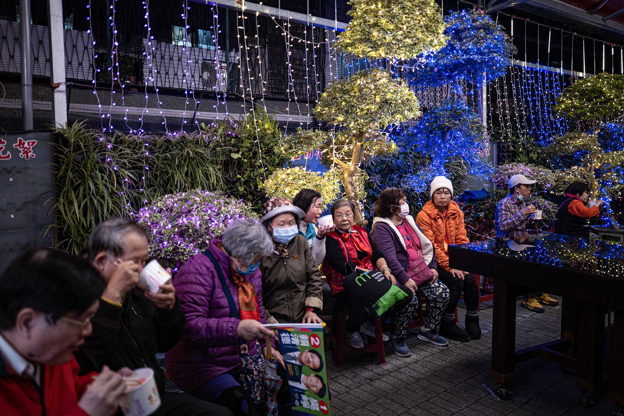 2023年12月26日,新北市,民进党立委候选人吴峥参香拜票,宫庙内的民众吃著米粉等食物。摄:陈焯煇/端传媒