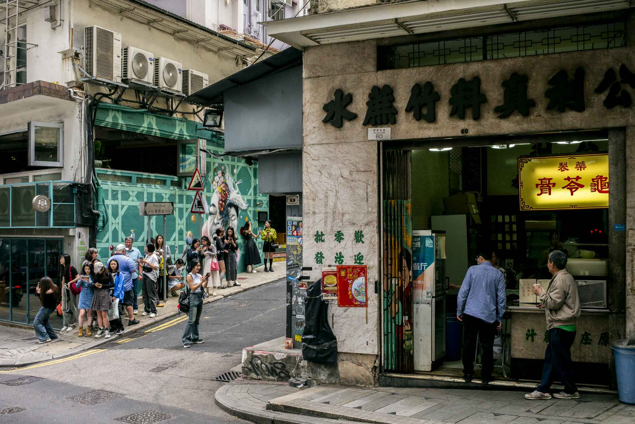 中环荷里活道,公利竹蔗糖水旁的涂鸦墙,长期都有游客排队拍照。摄:林振东/端传媒