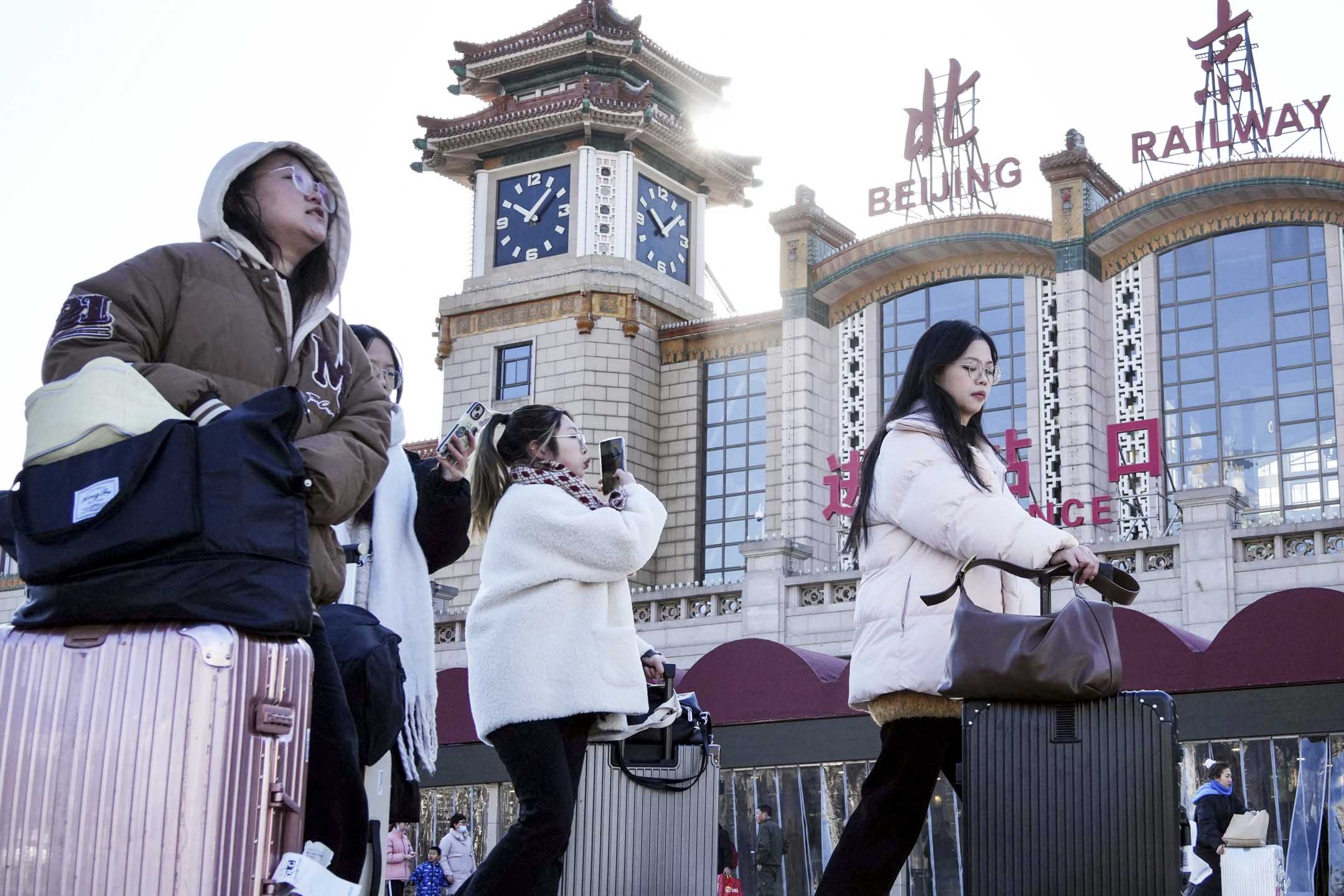2024年1月26日,中國北京,旅客攜帶行李在春節前從北京站出發。攝:The Yomiuri Shimbun via AP/達志影像