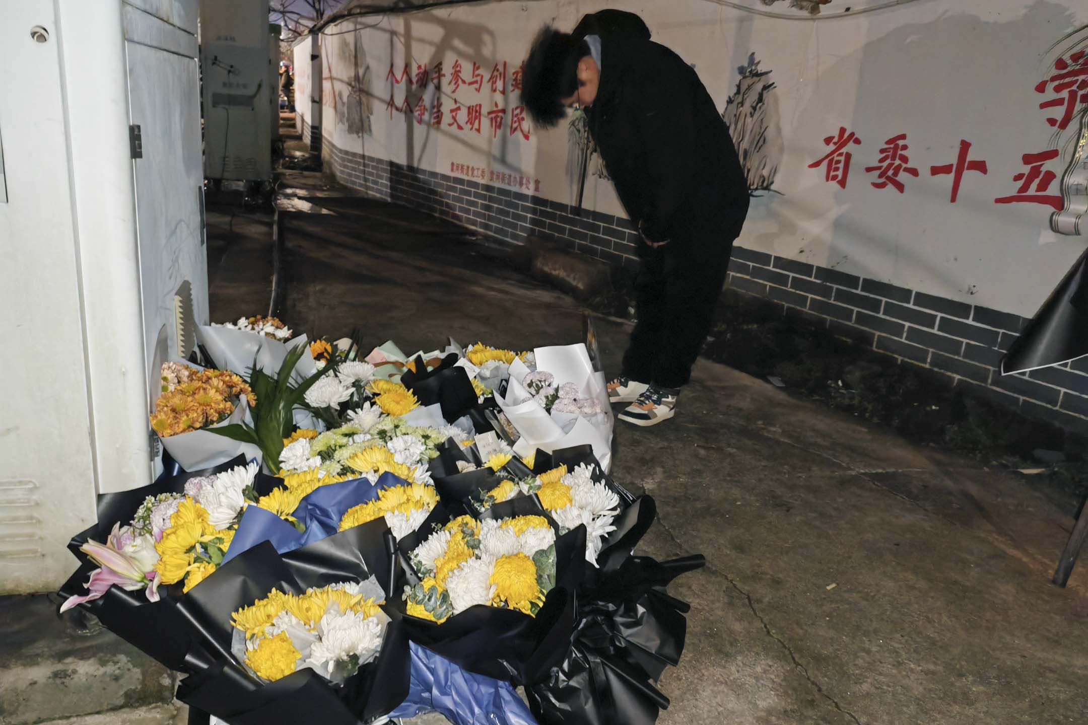 2024年1月25日,中国江西新余市一场大火导致39人死亡后,一名男子在火灾现场附近鞠躬哀悼罹难者。摄:VCG/VCG via Getty Images