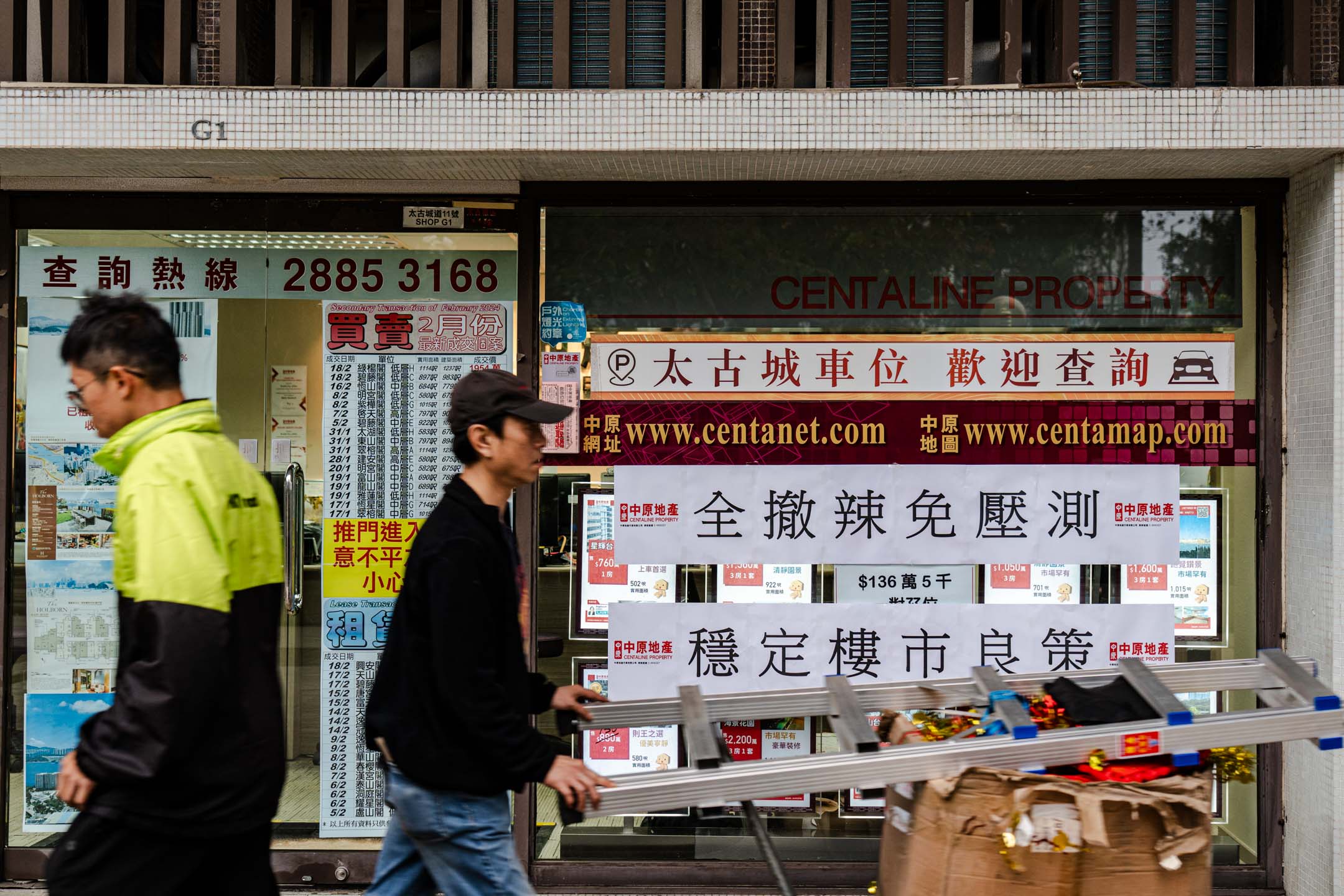 2024年2月28日,政府发布本届第二份财政预算案,宣布楼市全面“撤辣”后,有地产商在店铺外贴上欢迎的字句。摄:Ryan Lai/端传媒