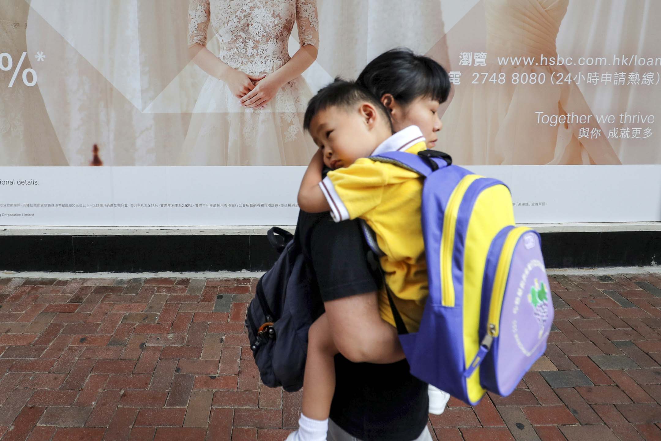 香港一位母親抱著孩子上學。攝:Amr Abdallah Dalsh/Reuters/達志影像