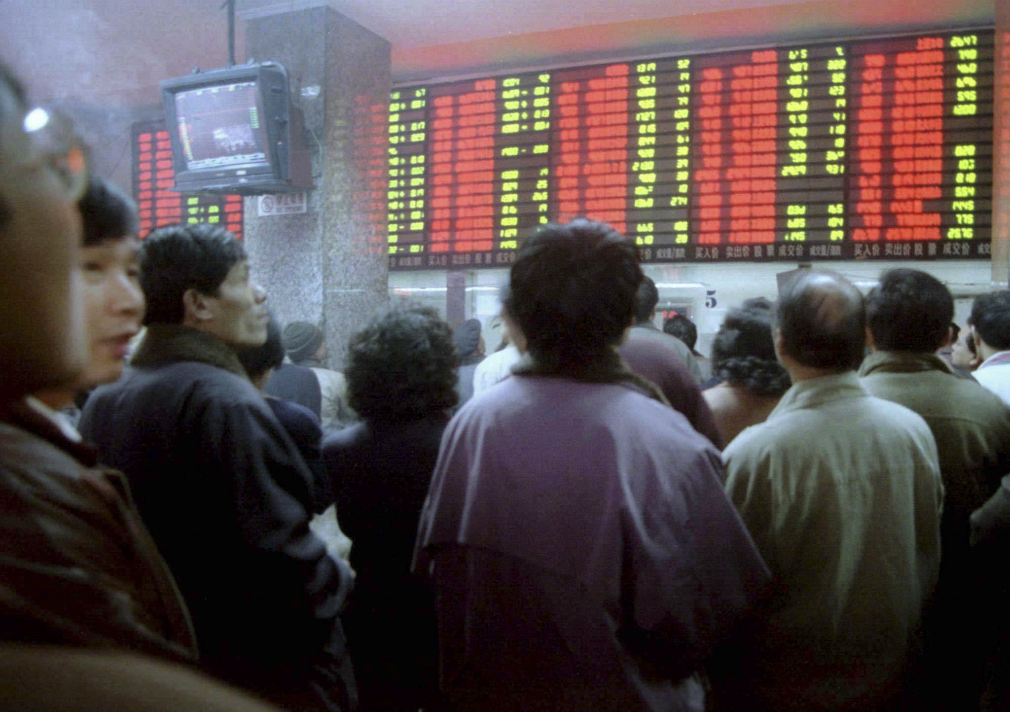 1997年2月21日,中国上海一家券商电子盘上股价闪烁,投资者蜂拥而至。图:Reuters/达志影像