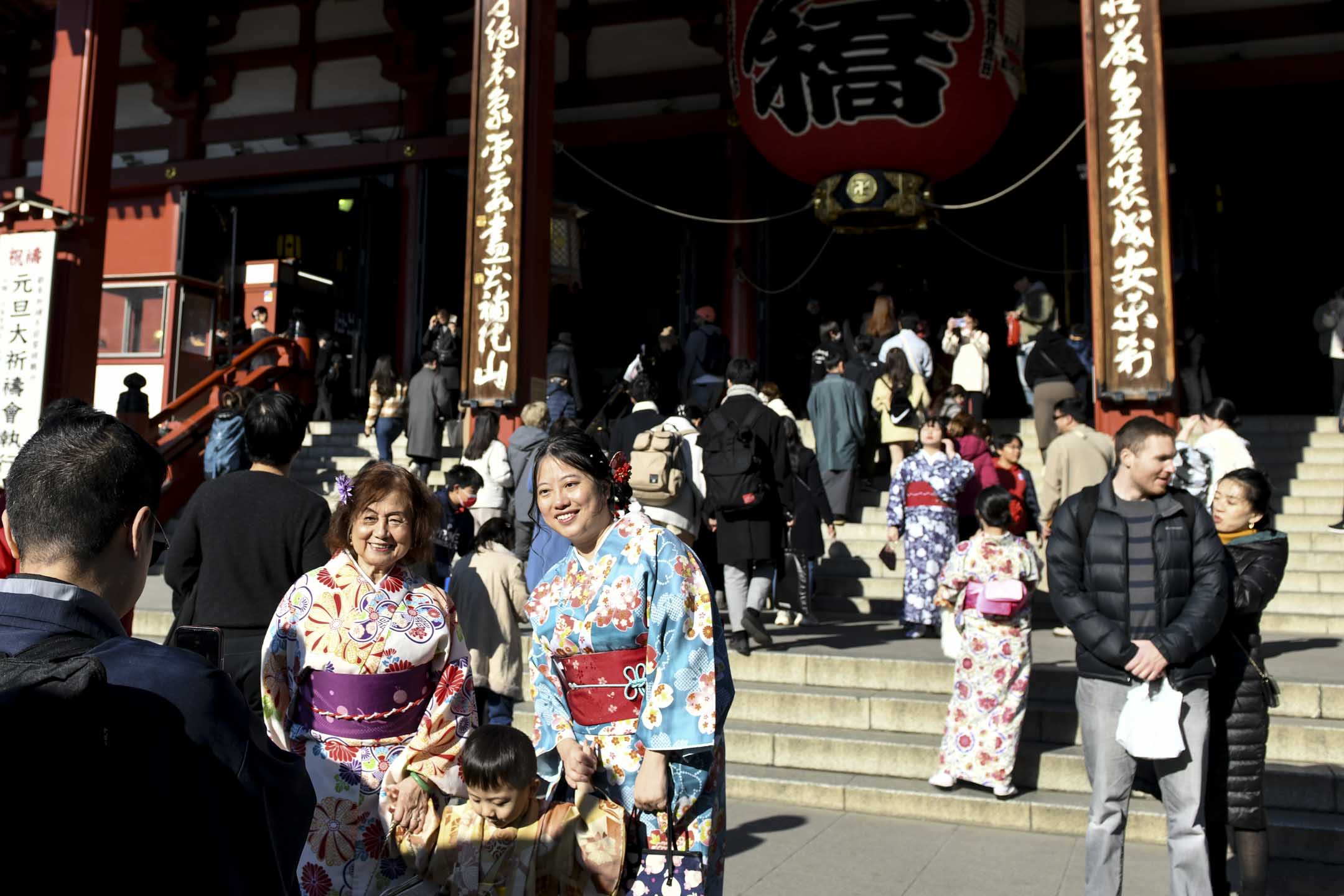 2023年12月26日,游客在日本东京浅草区浅草寺拍照。摄:Noriko Hayashi/Bloomberg via Getty Images