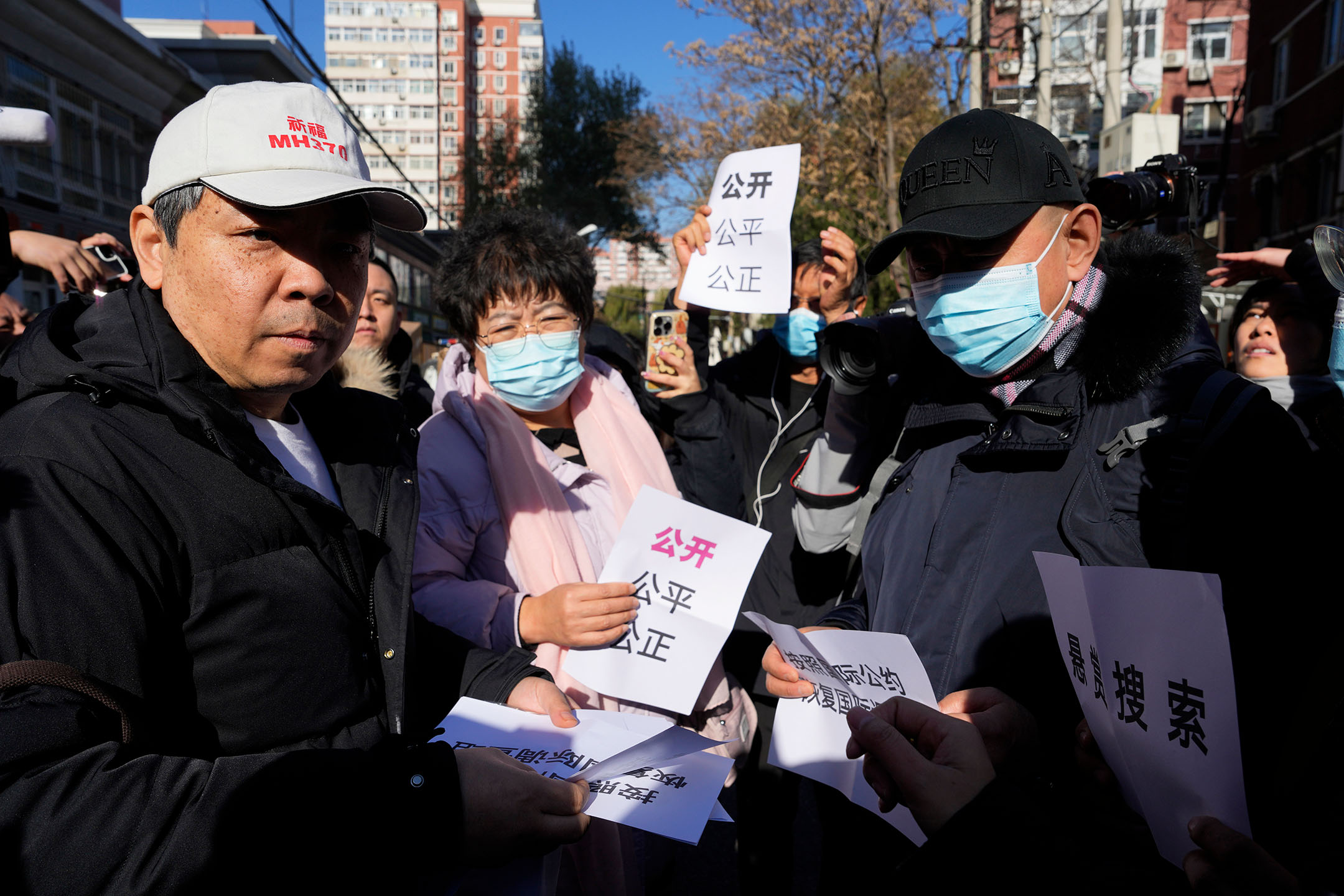2023年2月27日，中國北京，馬航370客機乘客親屬分發寫有「公開、公平、公正」字樣的紙條。攝：Ng Han Guan/AP/達志影像