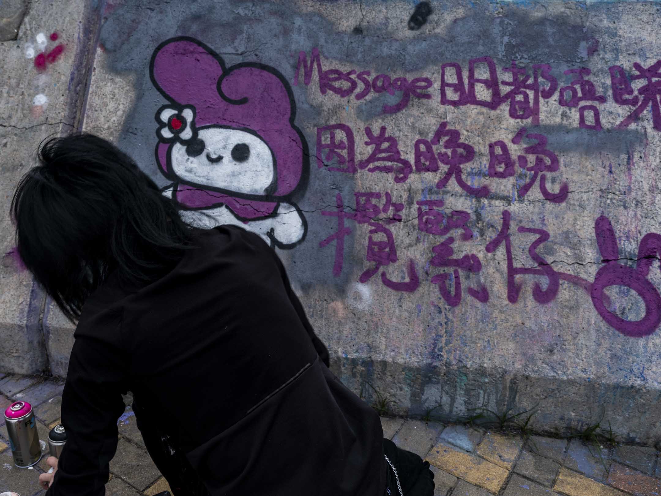 Melody在一個堤壩上進行塗鴉創作。攝:林振東/端傳媒