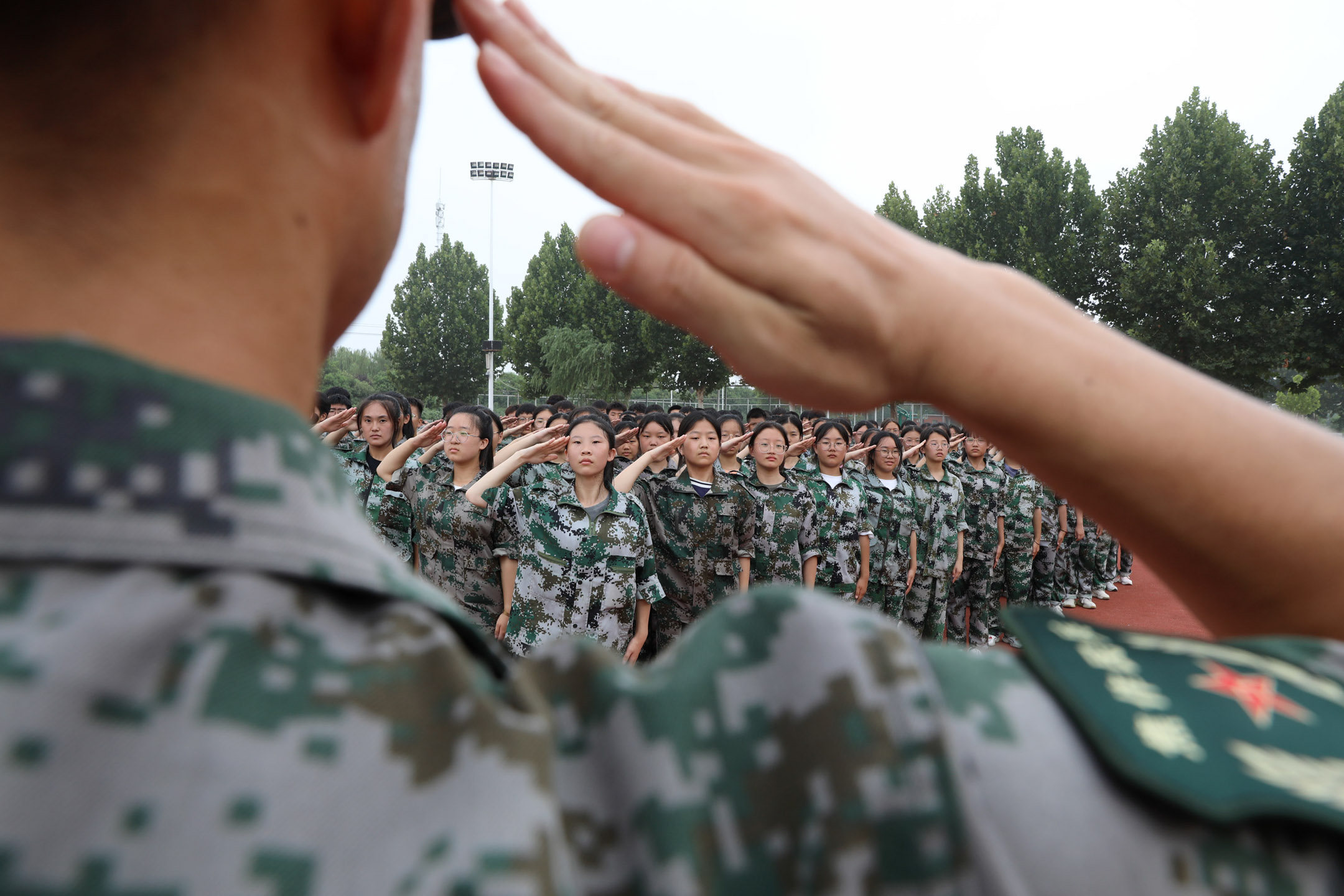 2022年8月14日,中國河南,一名教官在在軍事訓練中教高中新生行軍禮。攝:Xu Hongxing/VCG via Getty Images