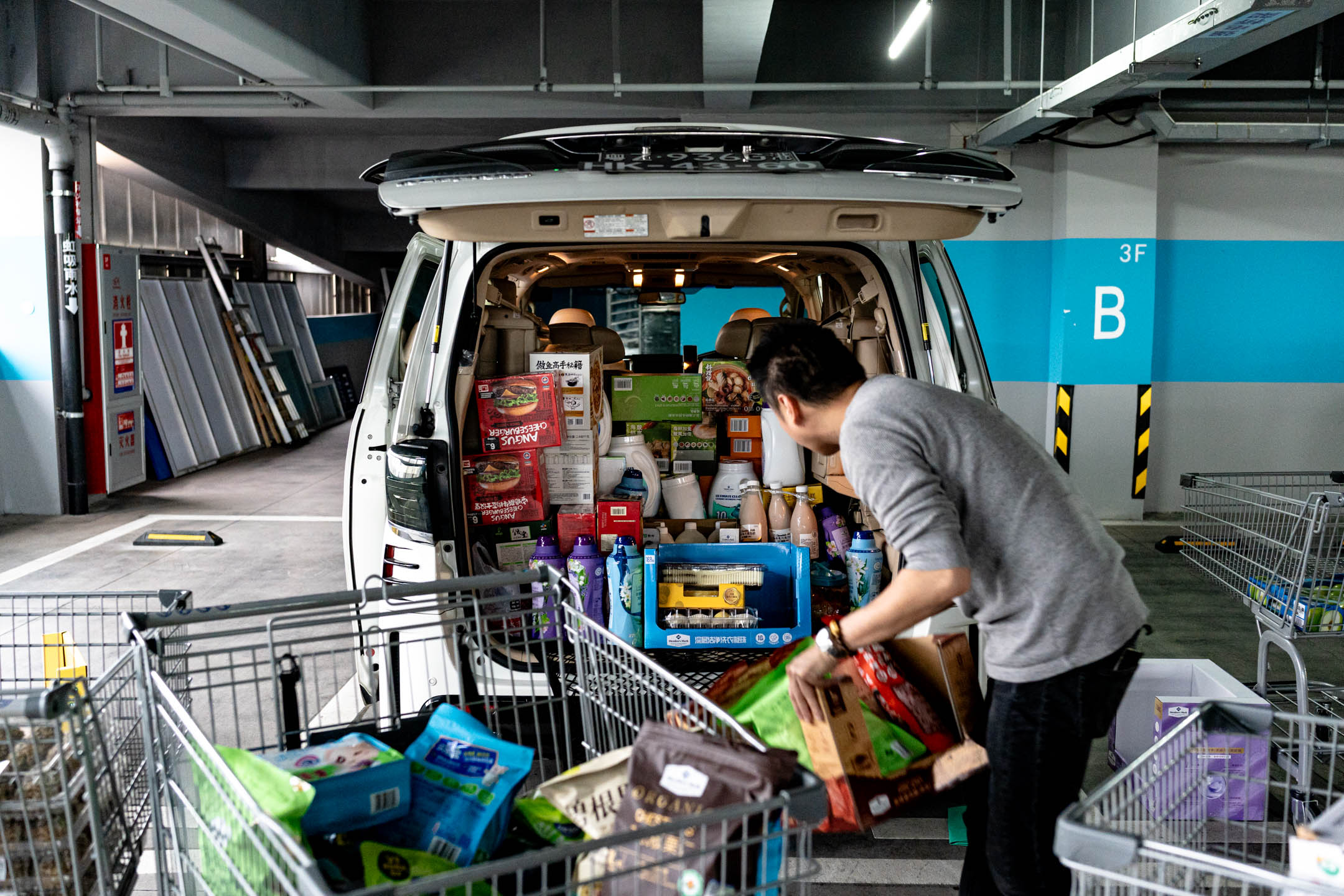 Korsy正在把商品放上自己的私家车。摄：Ryan Lai/端传媒