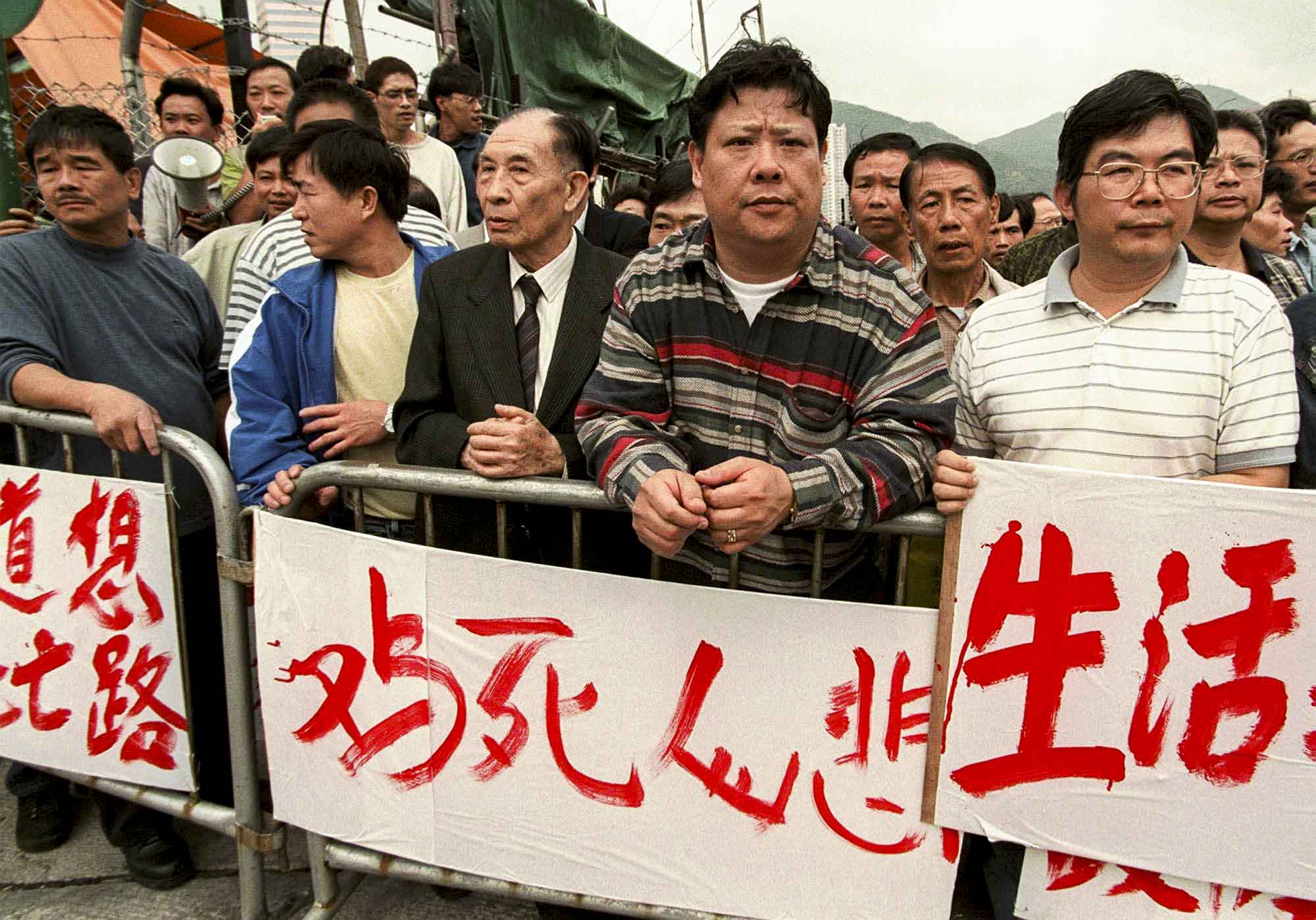 1997年12月31日,鸡肉摊贩聚集在香港的长长沙湾家禽批发市场外,要求政府因禽流感而屠宰香港所有鸡后给予更多赔偿。摄:Vincent Yu/AP/达志影像