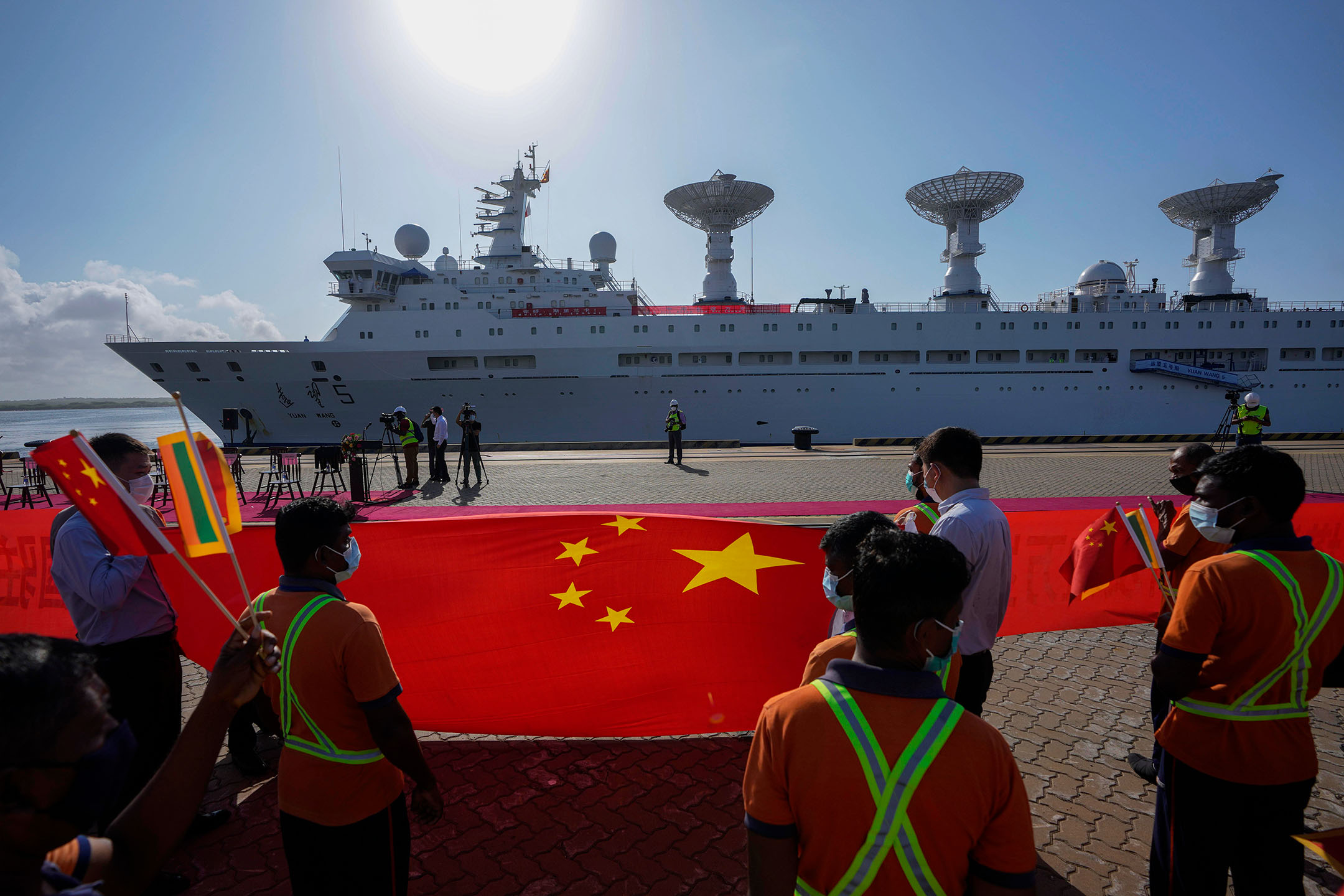 2022年8月16日,斯里兰卡,港口的工人举着中国国旗欢迎中国科考船远望5号抵达。摄:Eranga Jayawardena/AP/达志影像