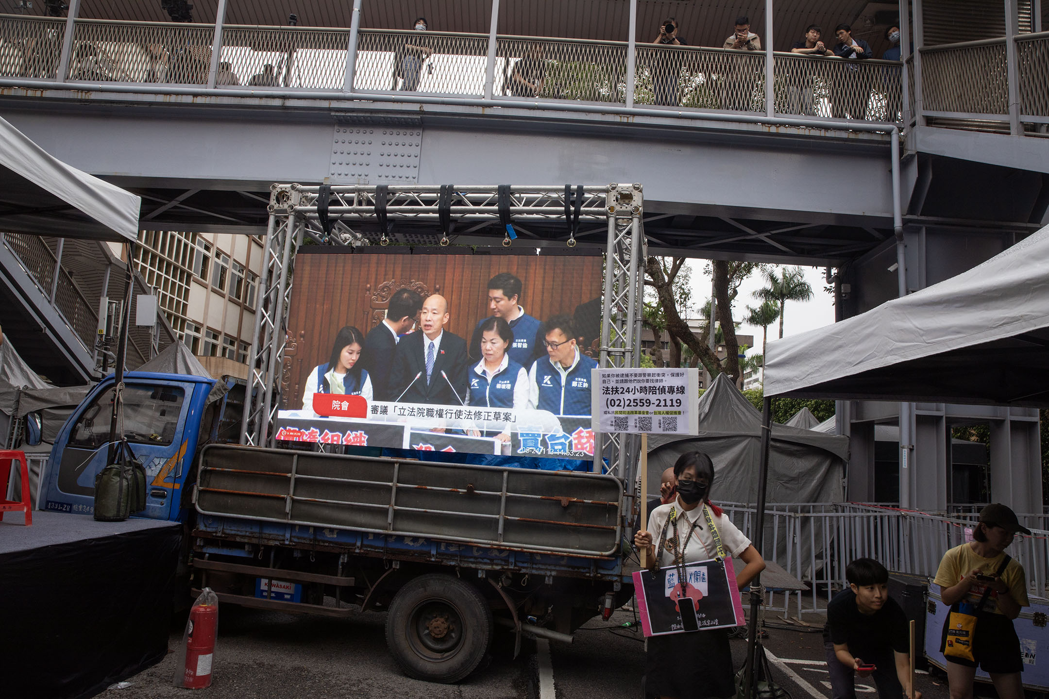 2024年5月21日,台北,立法院繼續處理藍白國會改革提案,場外播放議場内的情況。攝:陳焯煇/端傳媒
