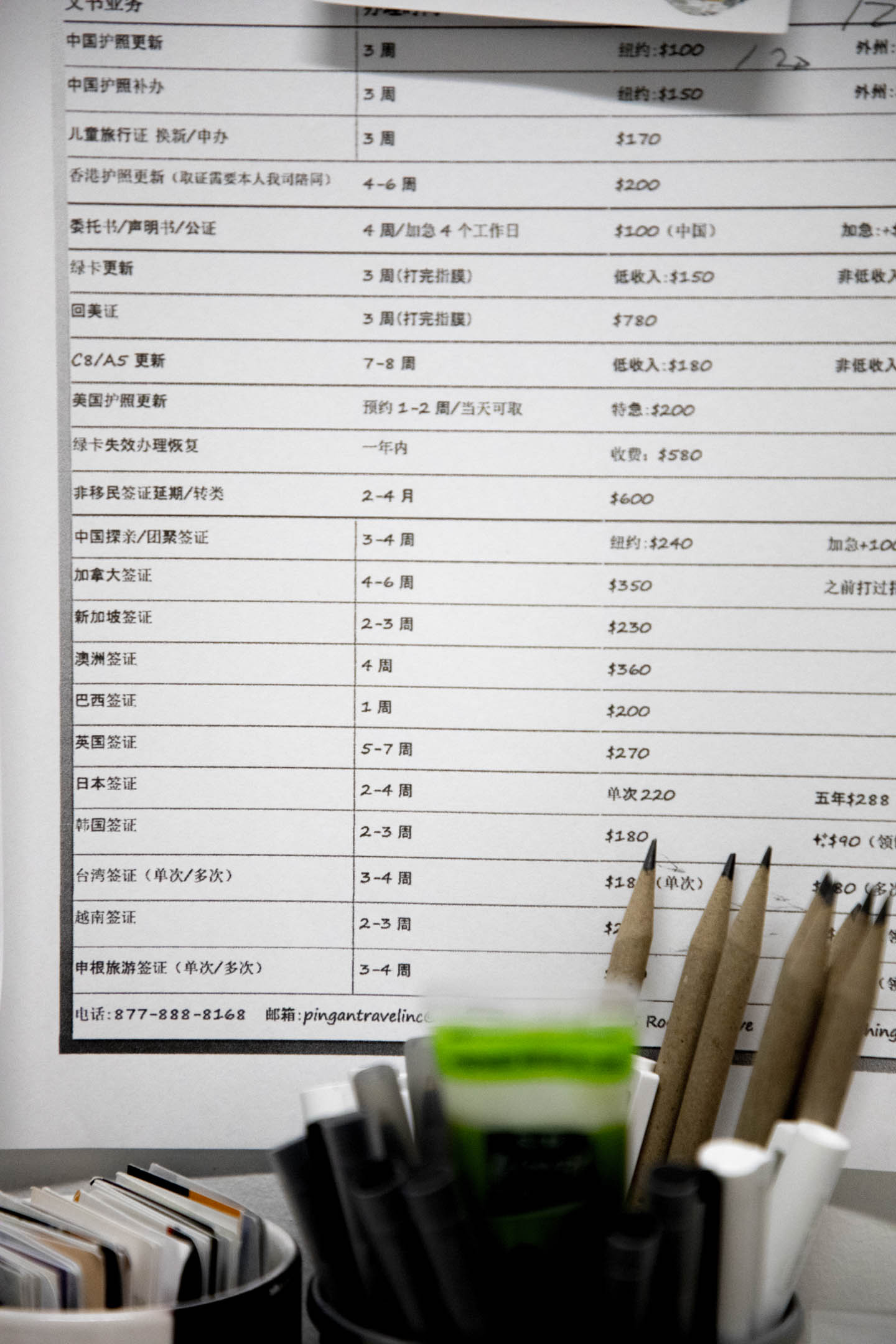 李小三经营的金桥翻译公司价目表和服务项目。摄:Hai Zhang/端传媒