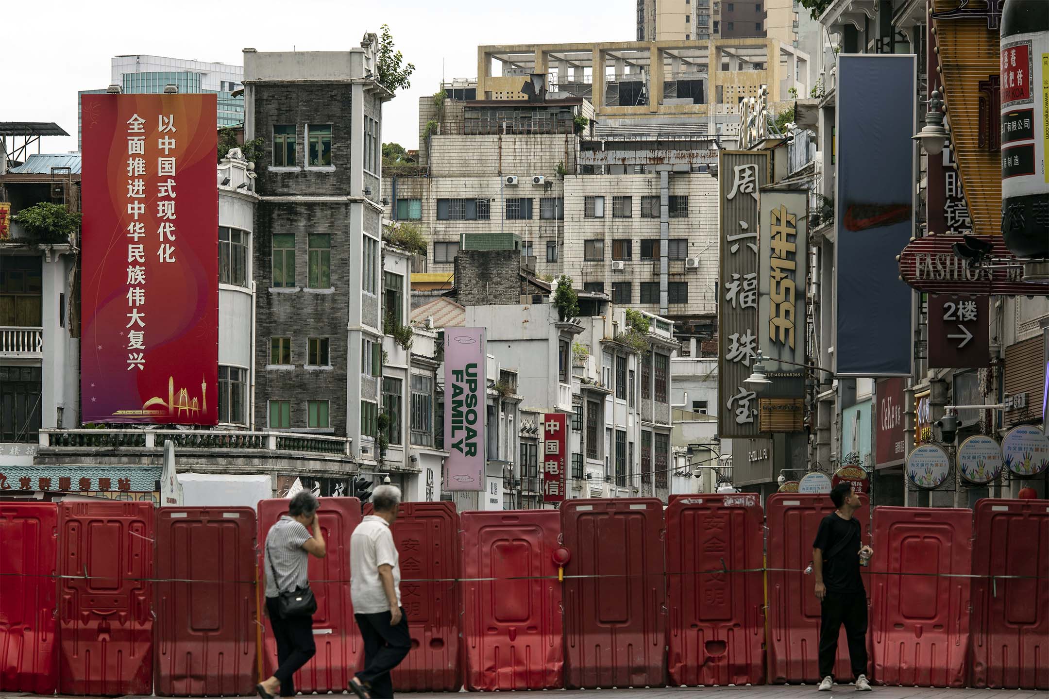 2023年8月11日,中國廣州,市民在路障前經過。攝:Qilai Shen/Bloomberg via Getty Images