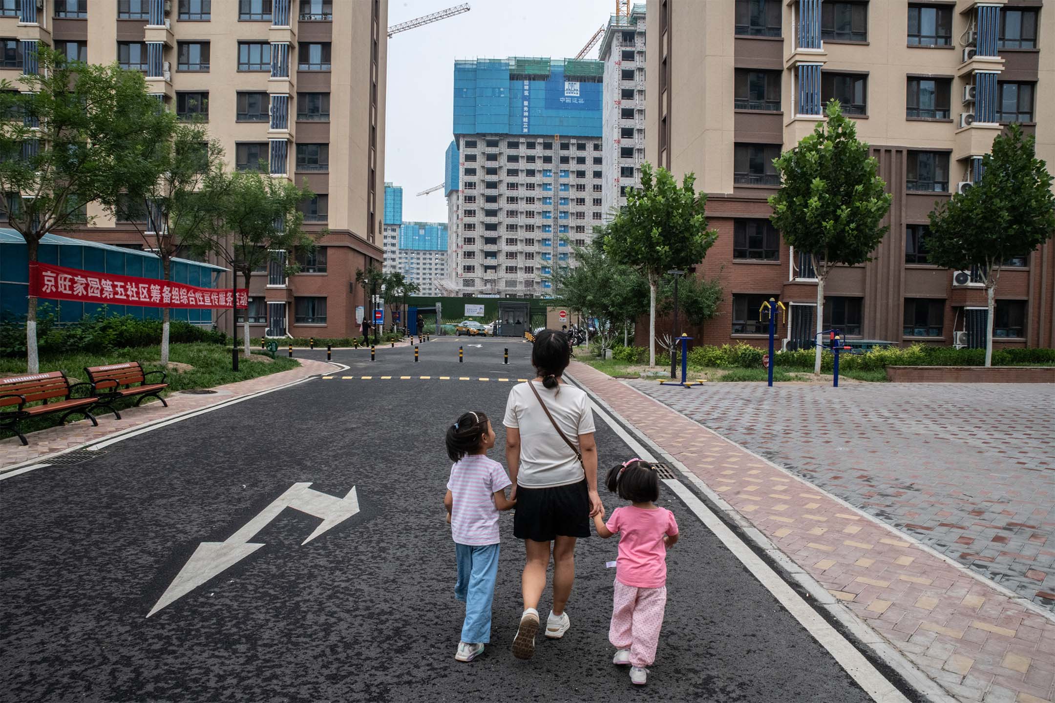 2023年8月11日,中國北京,人們正在看著興建中的住宅大樓。攝:Bloomberg via Gettyimages