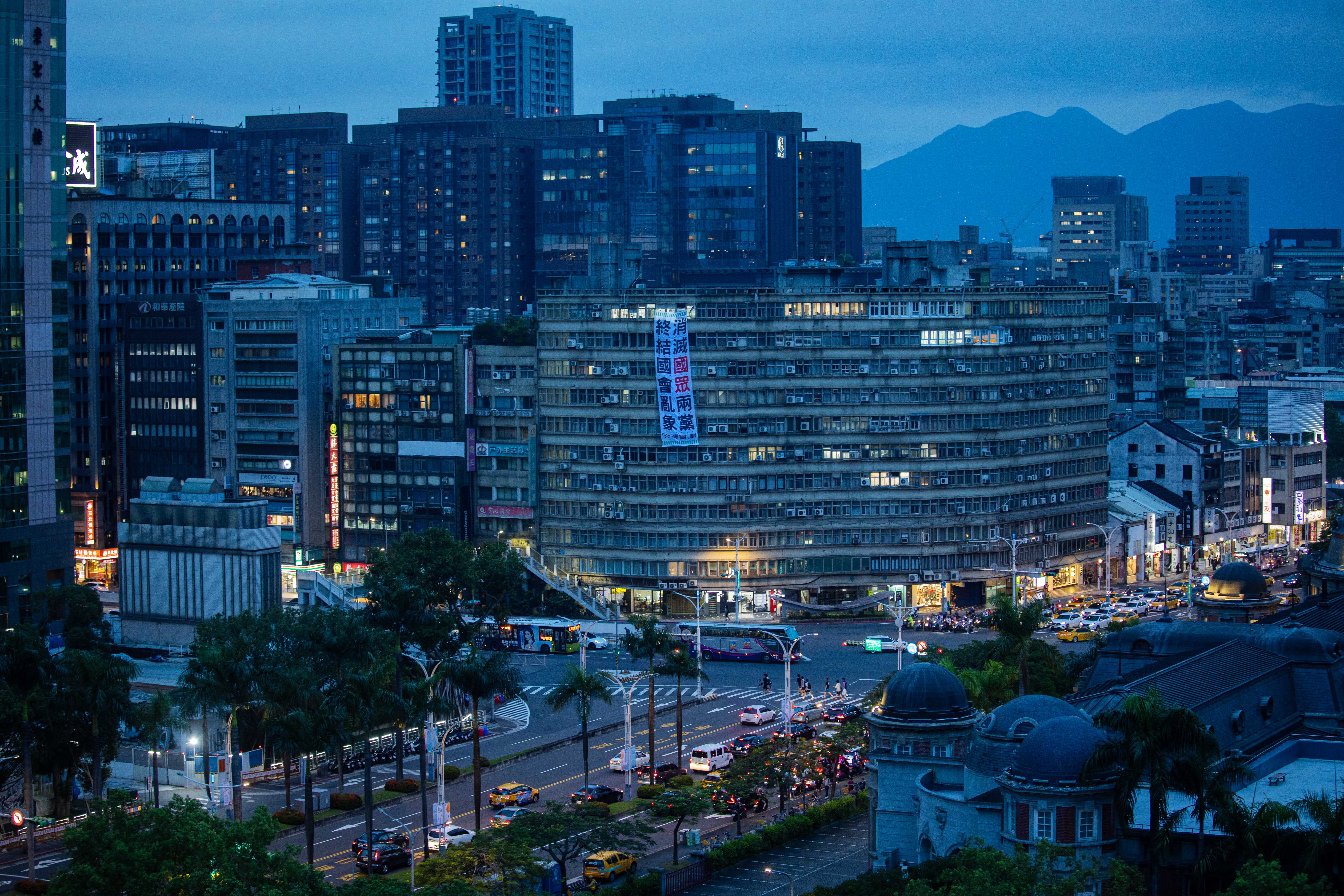 2024年6月20日,台北,立法院外一幢大廈外掛上反對國民黨和民衆黨的布條。攝:陳焯煇/端傳媒