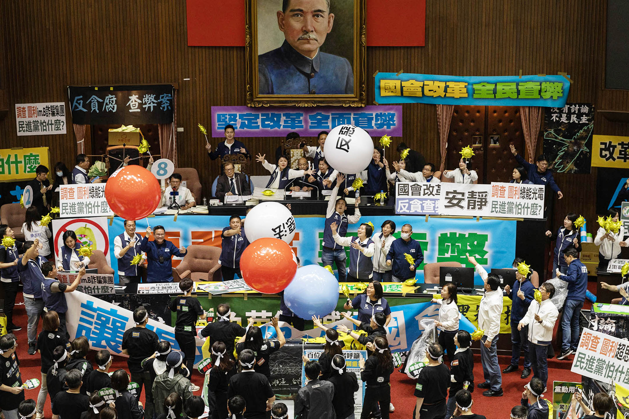 2024年5月28日,台北,立法院進行國會改革法案審議,立法院内民進黨向主席台抛汽球。攝:陳焯煇/端傳媒
