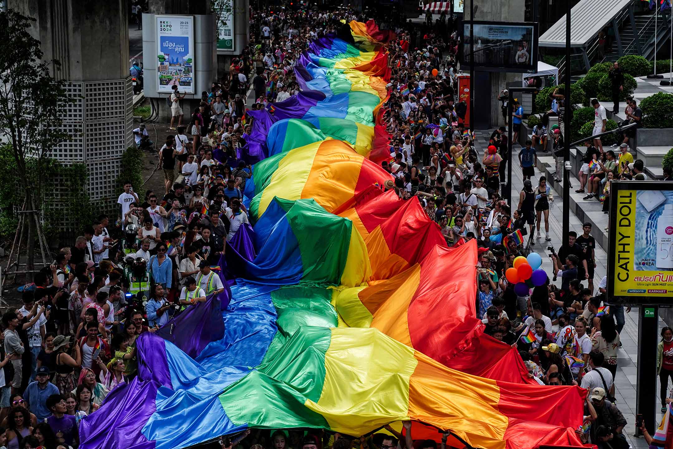2024年6月1日,泰国曼谷,人们举著一面巨大的彩虹旗参加 LGBTQ+ 游行,纪念骄傲月庆祝活动。摄:Anusak Laowilas/NurPhoto via Getty Images