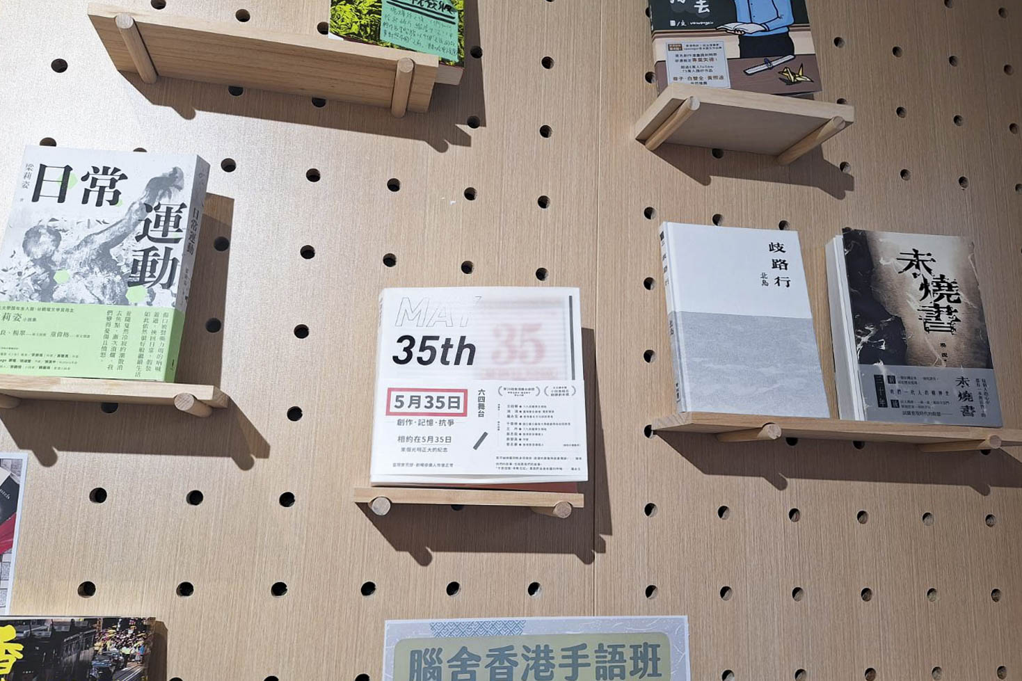 六四前夕,有警察到前民主派區議員黃文萱開設的獵人書店,登記出入人士身份證。2024年6月4日,書店門前紅色的「35/5」字樣依舊。書牆上,香港劇作家莊梅岩創作的舞台劇《5月35日》放在置中位置。