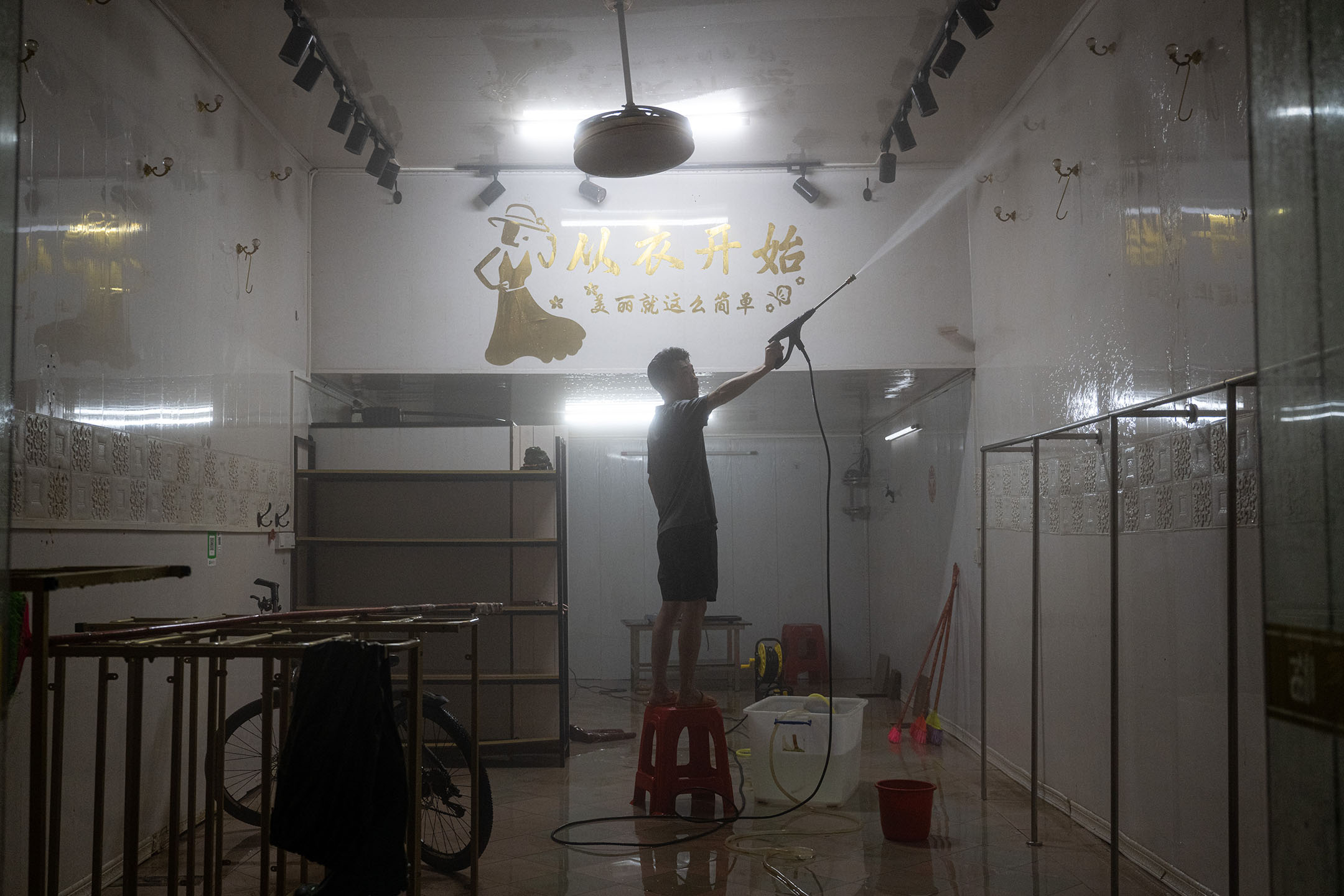 2024年6月19日,中国梅州,暴雨引发洪水,村民清理商店。摄:John Ricky/Anadolu via Getty Images