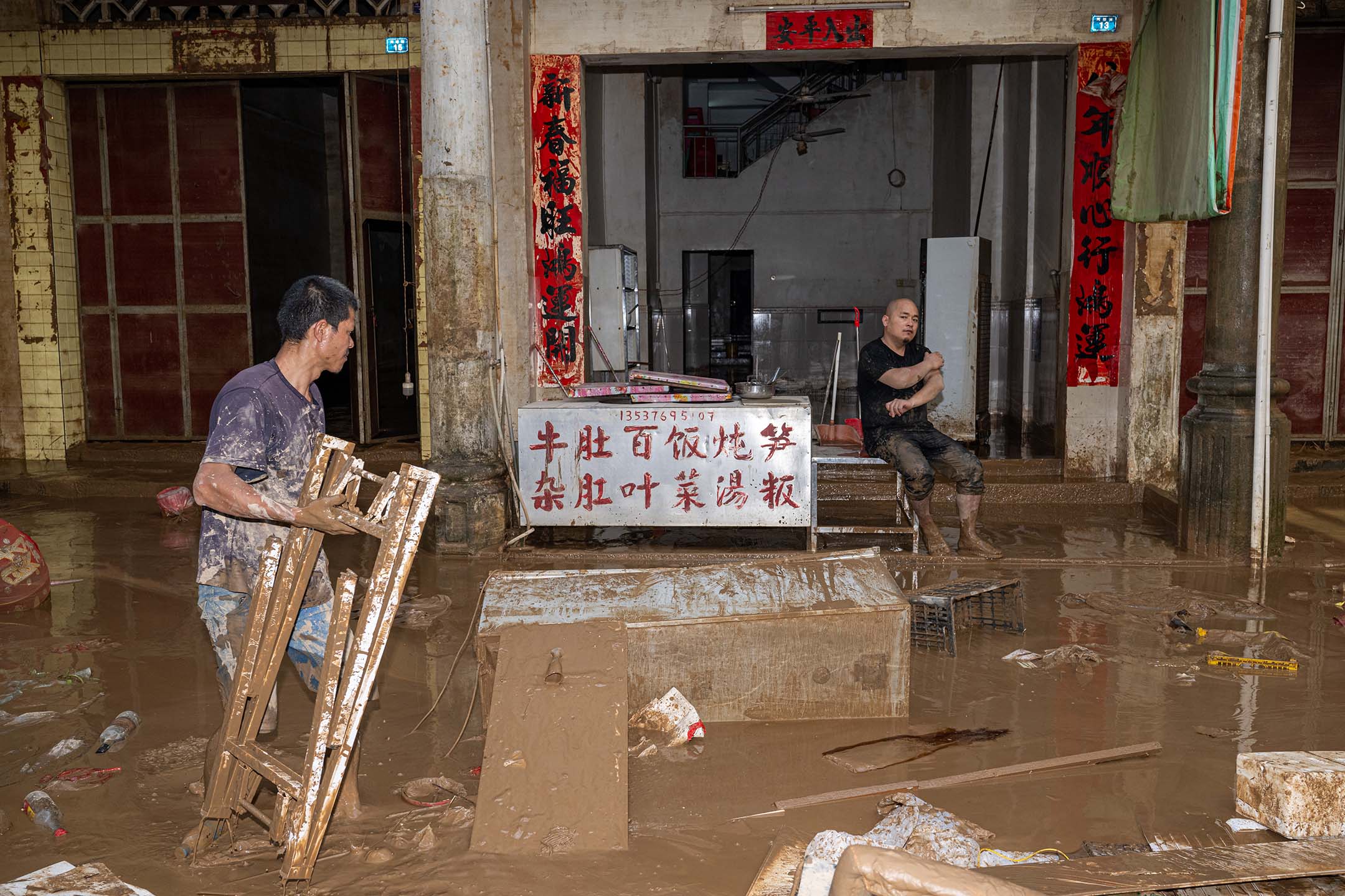 2024年6月19日,中国梅州,暴雨引发洪水,村民清理垃圾。摄:John Ricky/Anadolu via Getty Images