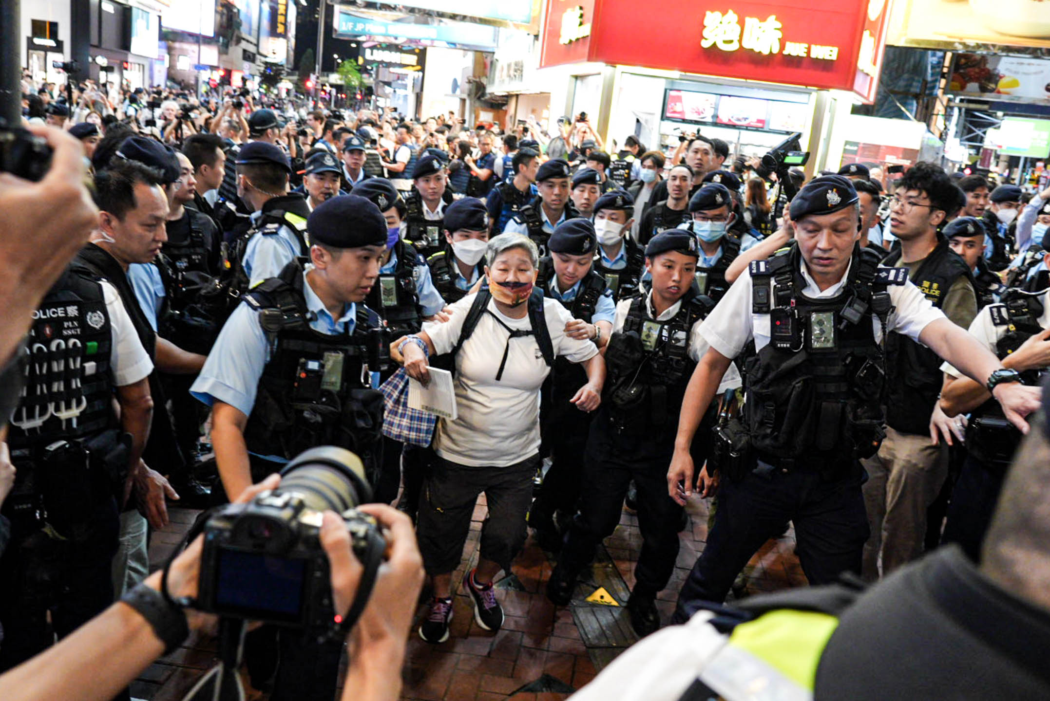 2024年6月4日,一名女士被警方包圍後帶上警車。攝:Ryan Lai/端傳媒