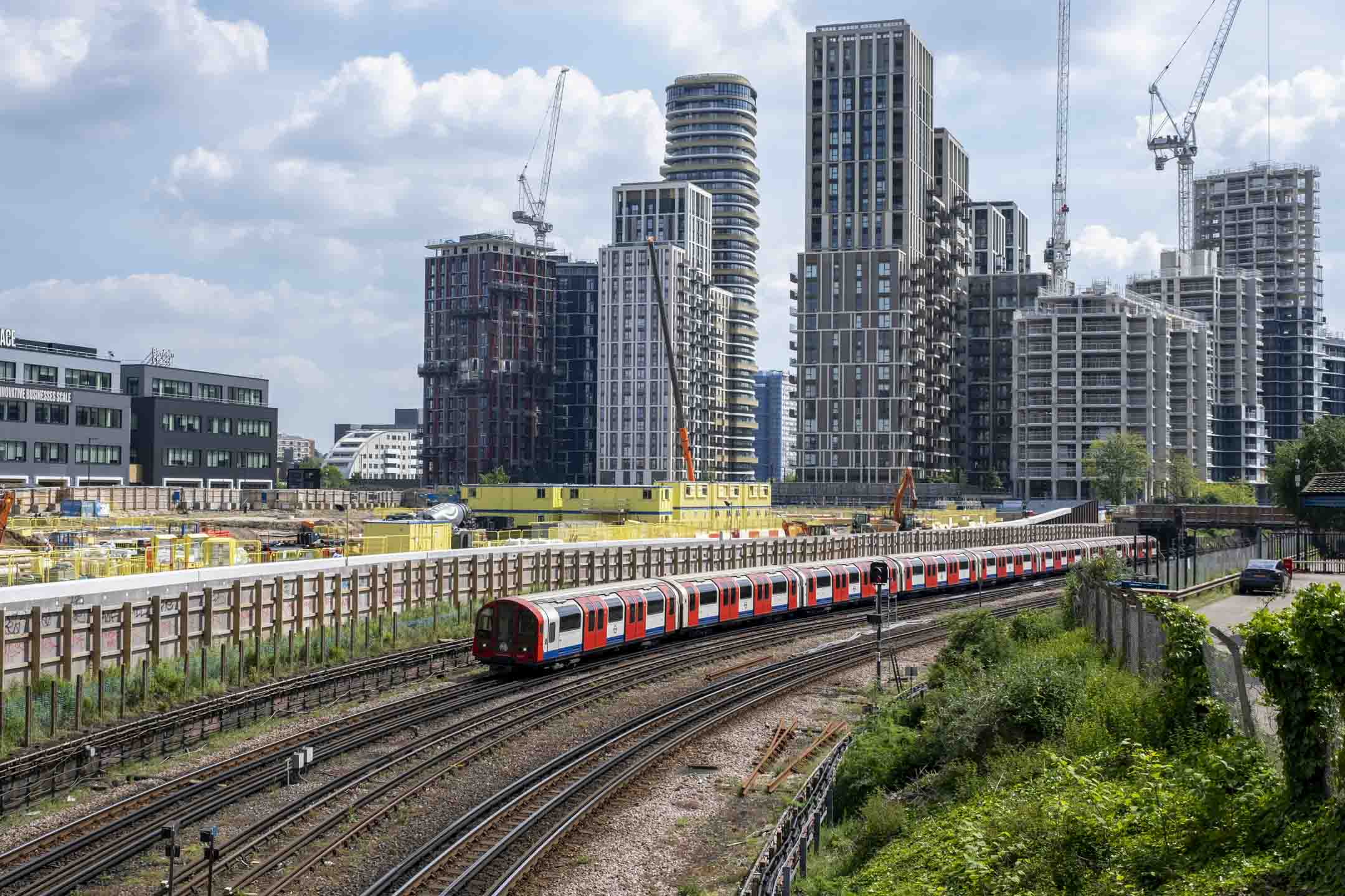 2024年5月9日,英國倫敦白城大規模重建計畫,地鐵列車經過正在興建的高層公寓。攝:Mike Kemp/In Pictures via Getty Images